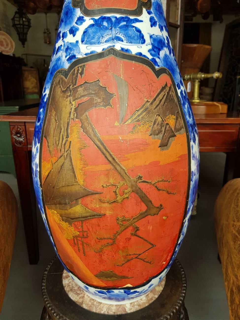 Large 19th century Japanese porcelain vase with blue under glaze painting and black lacquered scenes with images of landscapes, birds, etc., it is marked with character on the bottom but unclear, the neck is shortened and made in to a lamp with