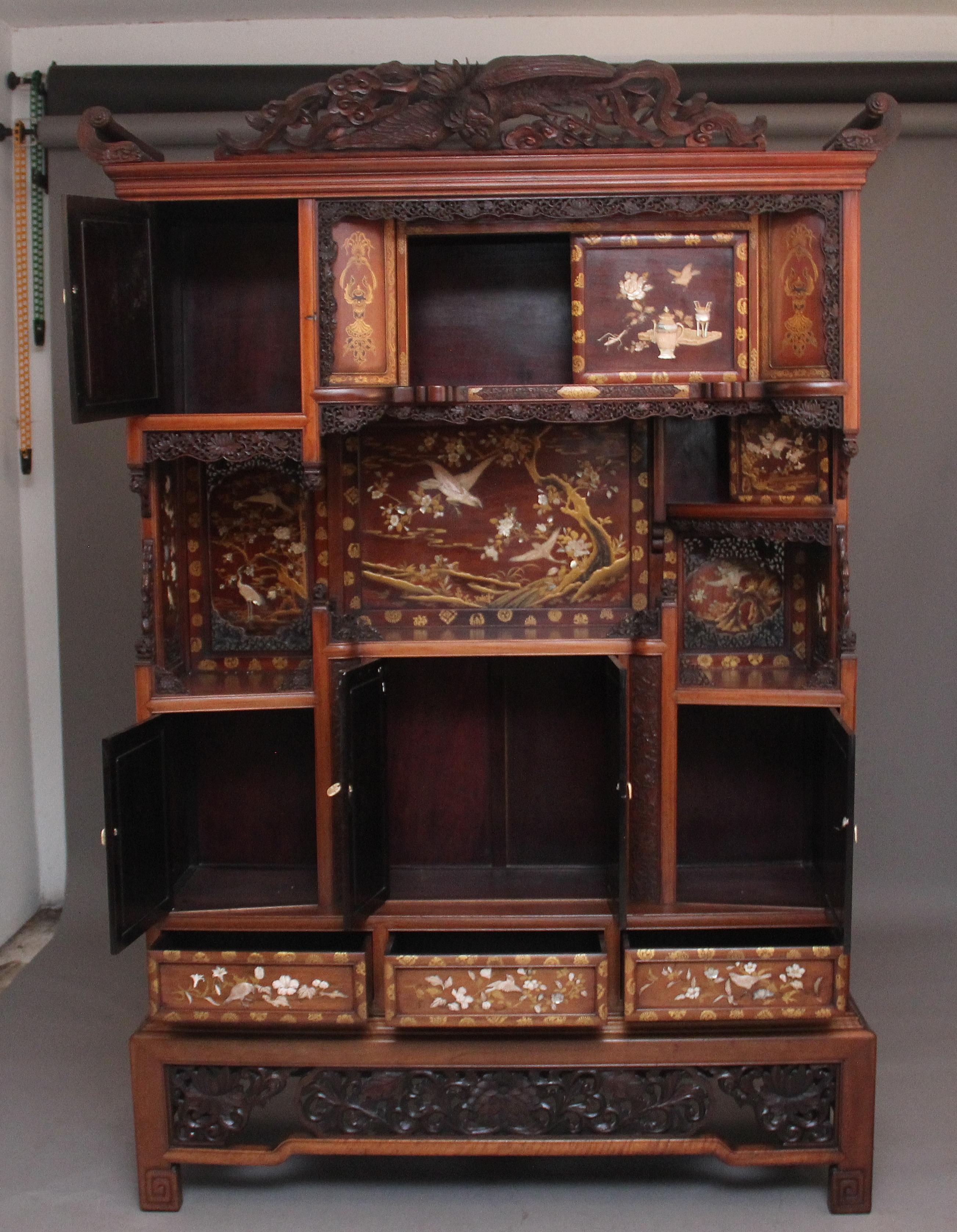 A fabulous quality and impressive large Japanese hardwood Shodona from the Meiji period, the lovely carved pediment incorporating a large winged bird and having decorative C scrolls either side, the cabinet consisting of various shelves, panels,