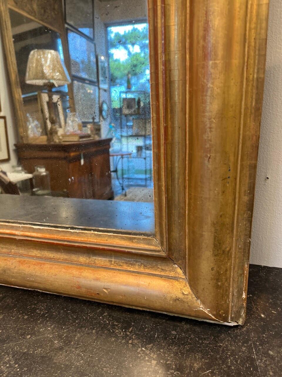 Grand miroir doré Louis Philippe du 19ème siècle, avec quelques pertes sur le cadre et quelques pertes d'argent sur le miroir d'origine.
