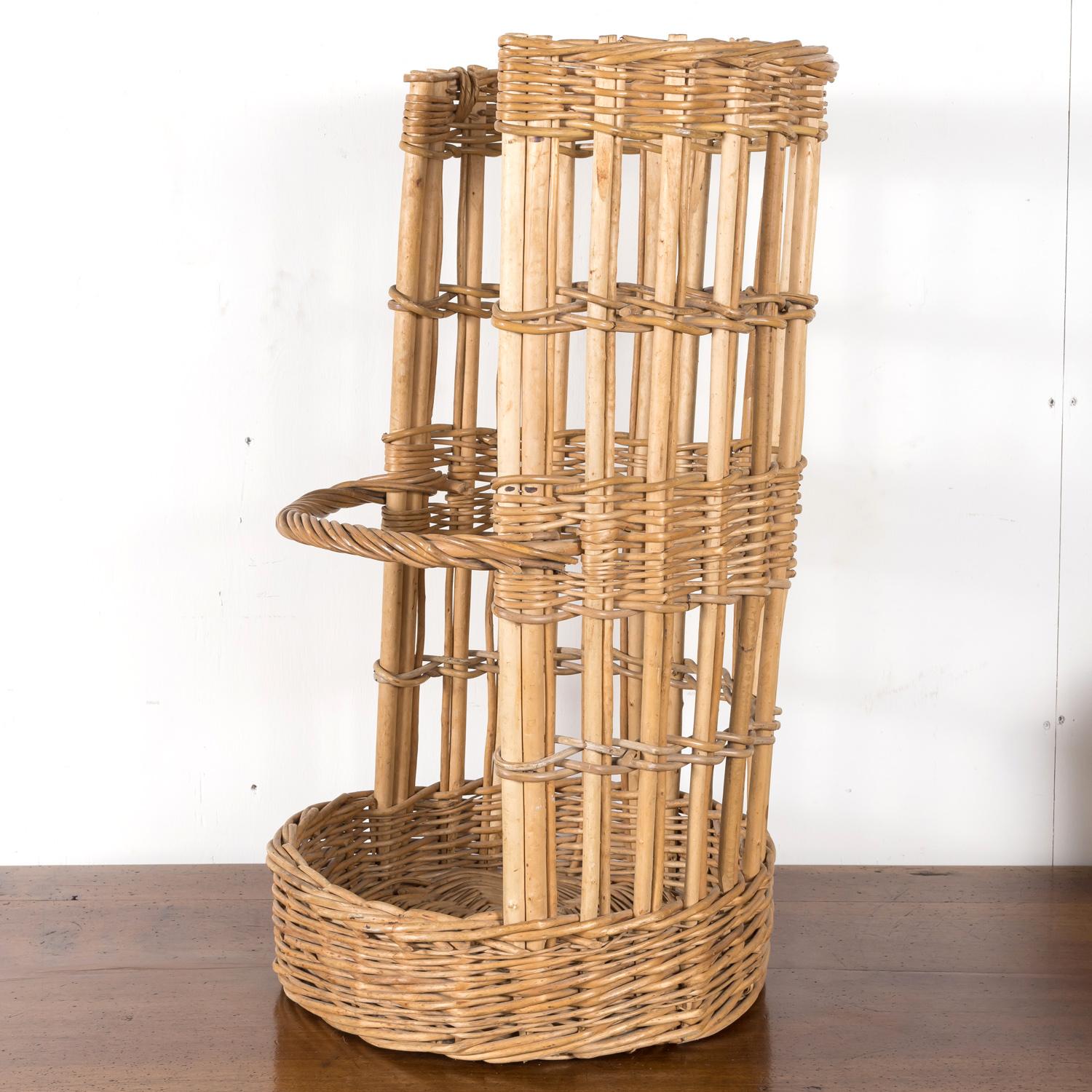 A hard to find open-sided 19th century French boulangerie baguette basket, circa early 1900s. This semi-circle willow basket with a lovely aged patina was used to showcase freshly baked baguettes in a French boulangerie. Wooden slat bottom runners