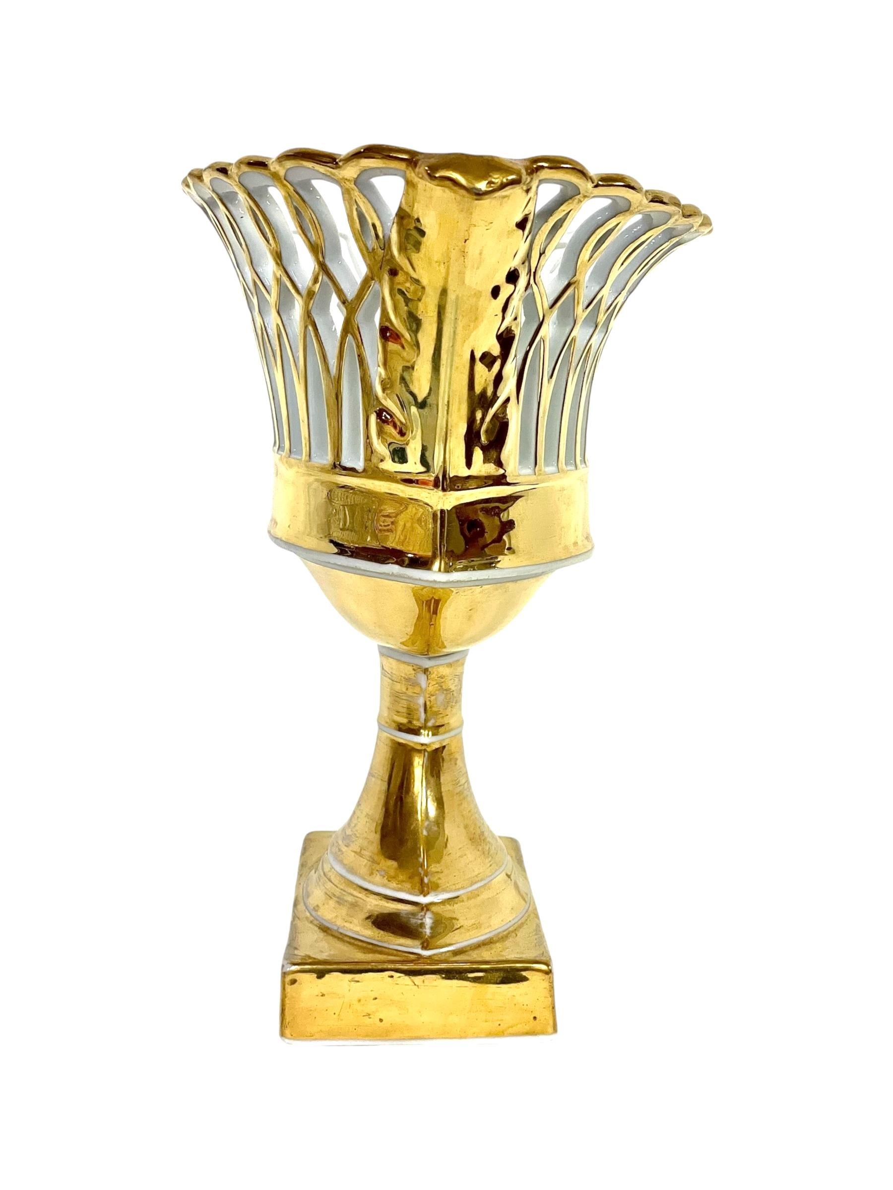 Llamativa compota o cesta de fruta calada de porcelana parisina, totalmente dorada en su exterior y bellamente modelada en estilo oval aplanado. La cesta presenta un diseño delicadamente reticulado en sus laterales, con lazos entrelazados de