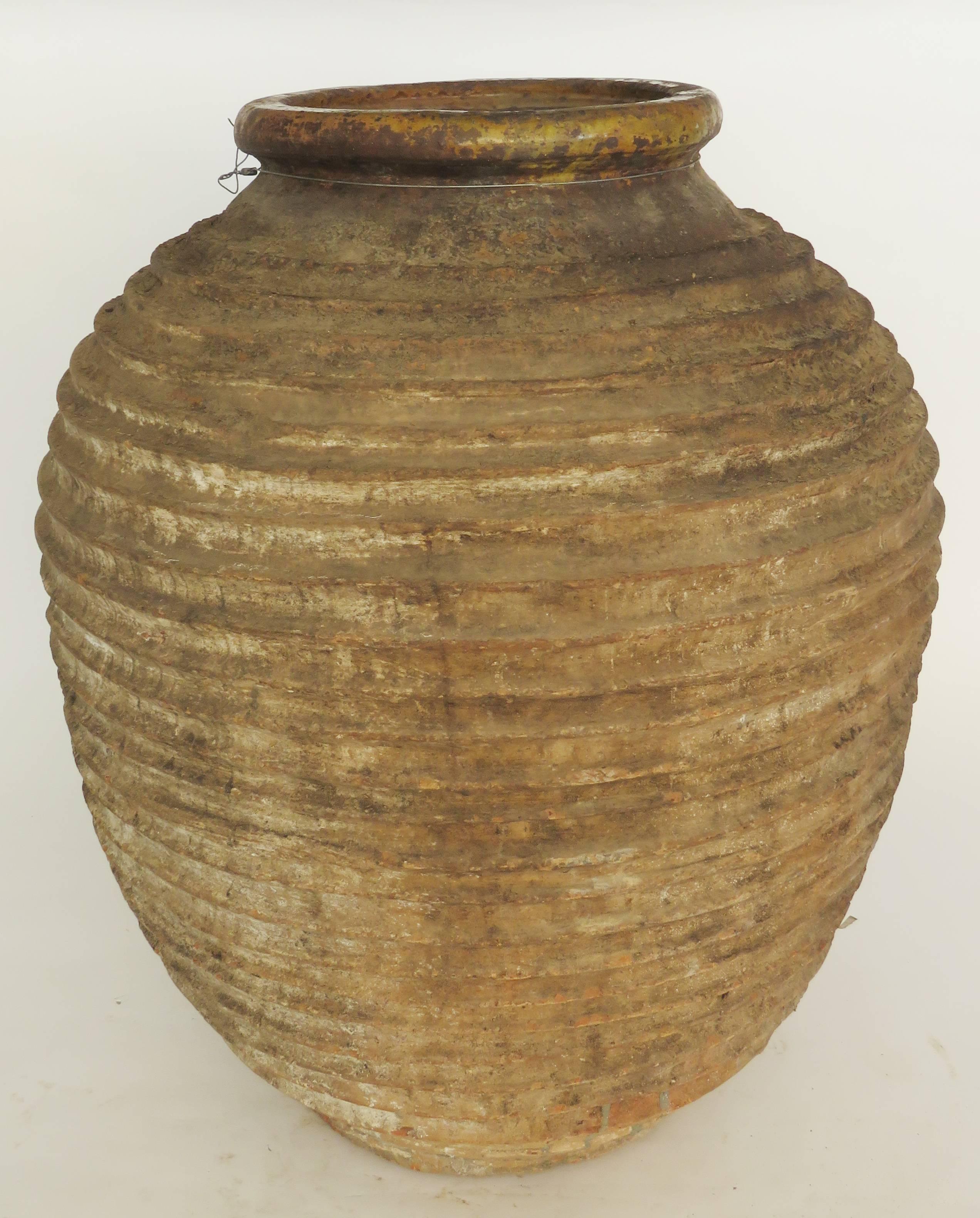 Hand coiled ribbed ceramic jar decorated with mustard yellow glazed around neck. Mouth: 10 1/2 