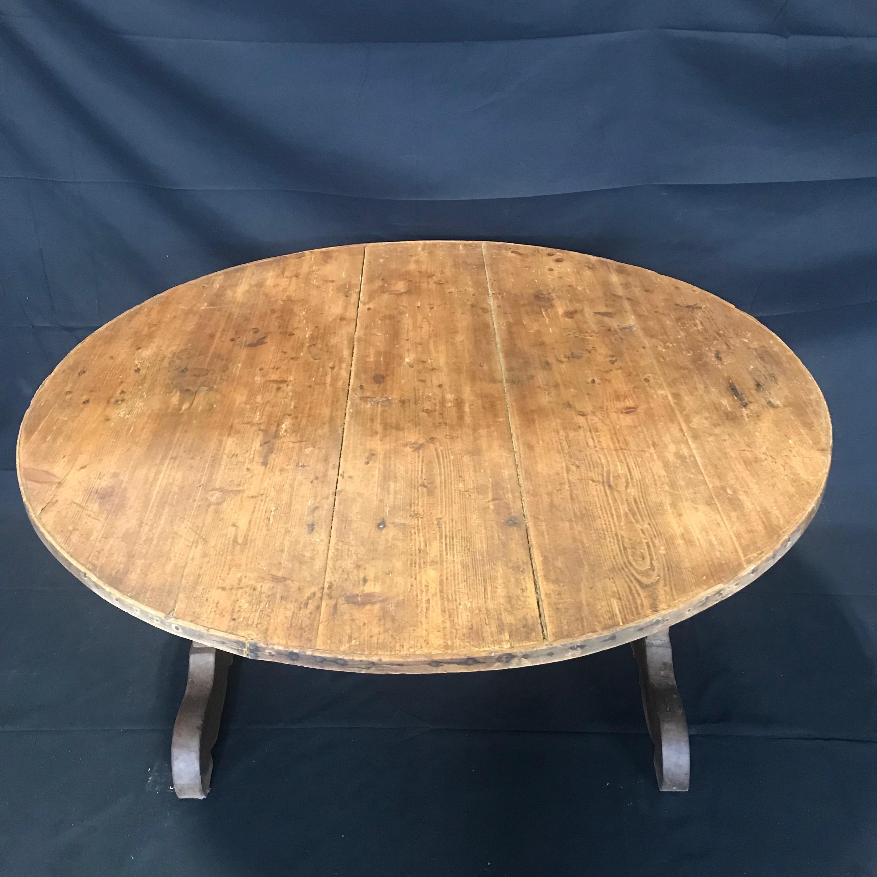 French wine tasting table, also known as a vendage or vigeron table, which was once used in the vineyards of France for tasting wine or enjoying a meal. This table would be suitable for use in a breakfast area or wine cellar. Featuring a tilt top,