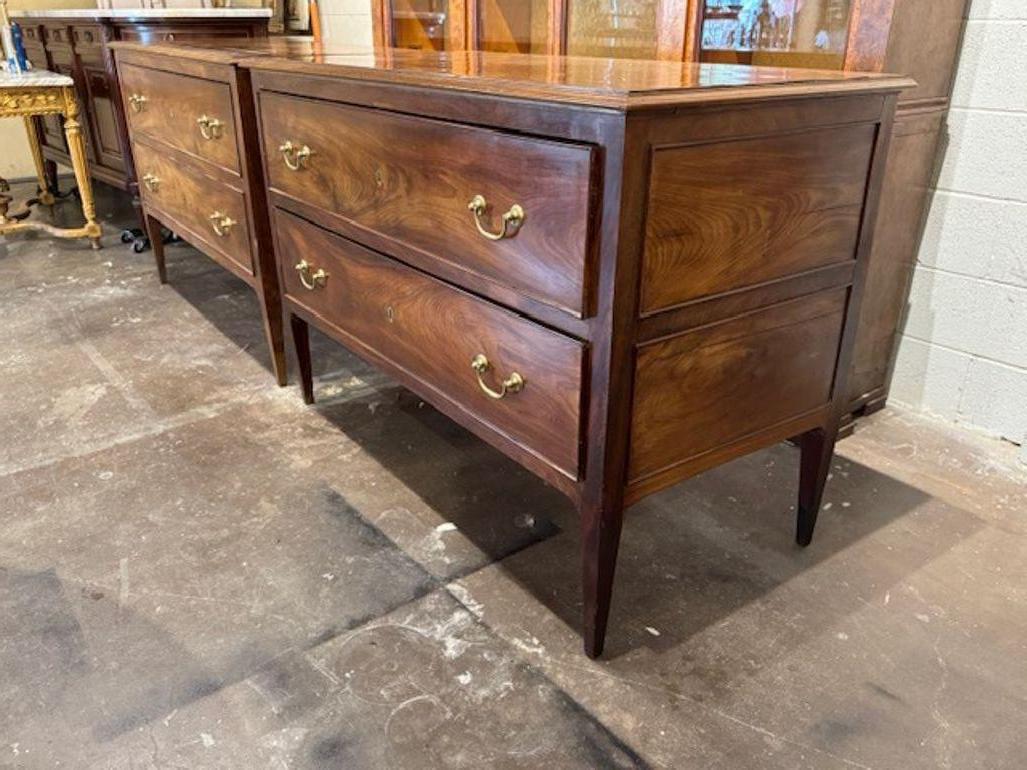 This product is a pair of  large scale English mahogany commodes from the 19th century. These chests represent traditional English design, featuring intricate craftsmanship and a timeless appeal. These commodes provides ample storage space with 2