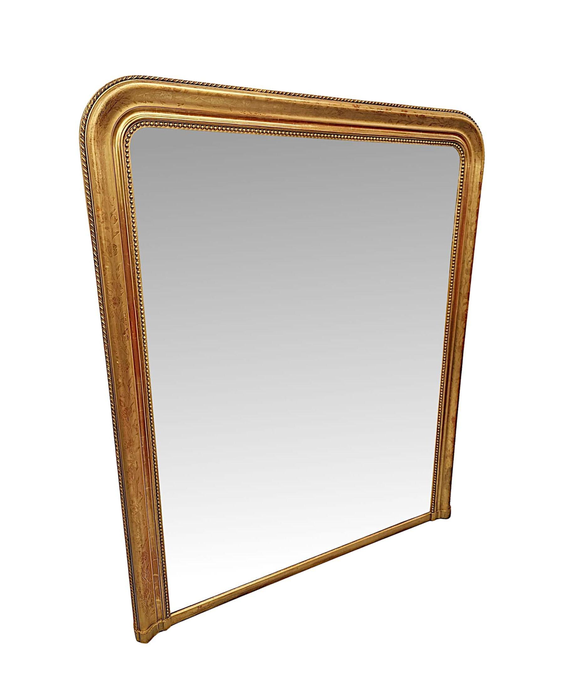 Precioso espejo sobremantelado de madera dorada del siglo XIX, elegantemente sencillo, de excepcional calidad y grandes proporciones.  La placa de cristal de espejo de forma rectangular con las esquinas superiores curvadas está dentro de un marco de