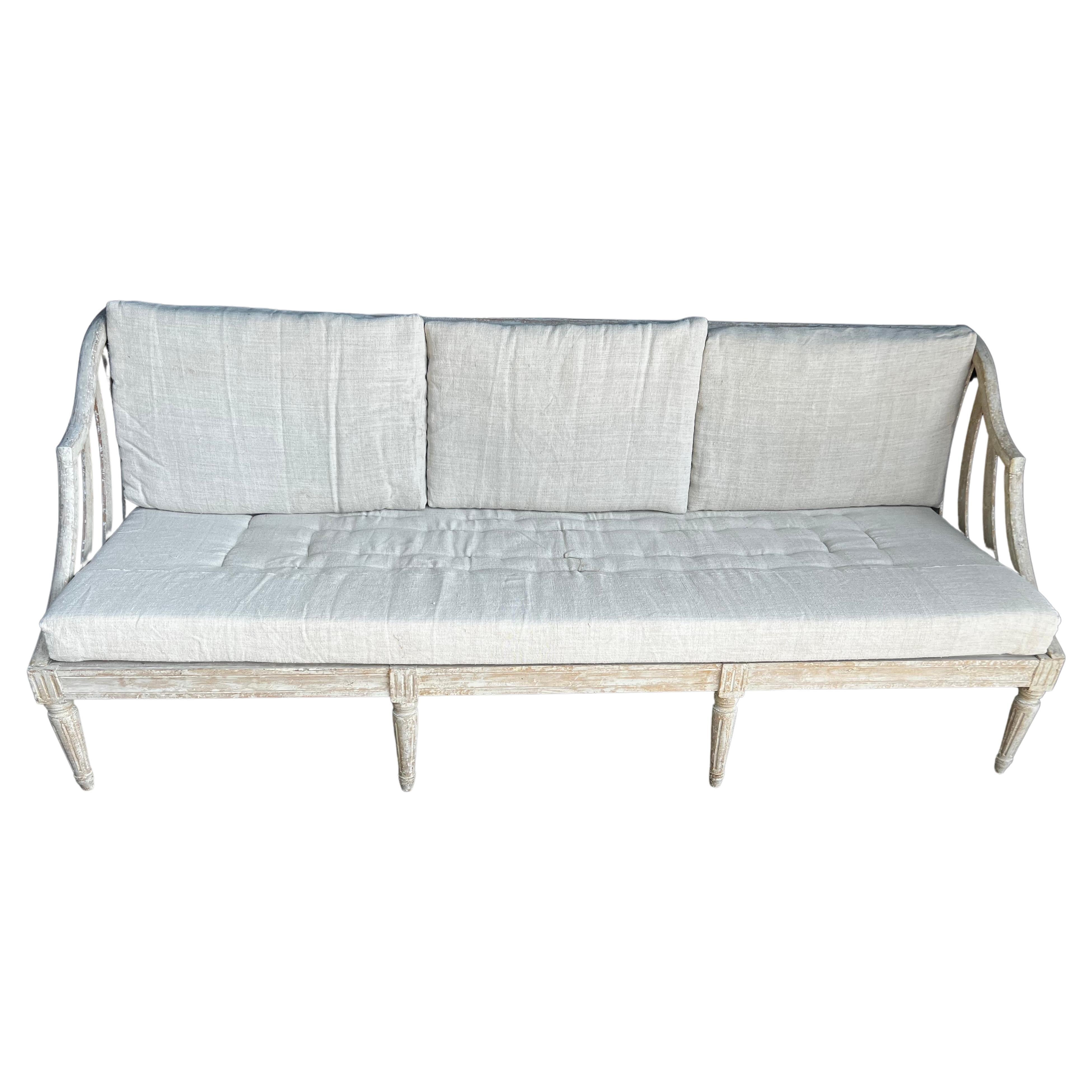 A beautiful, large and very rare large Swedish Gustavian sofa with new upholstered seat cushions added. This piece is very unique and rare with the grande scale and featuring side curved arms. Dry scrapped to the original paint color. This is one of