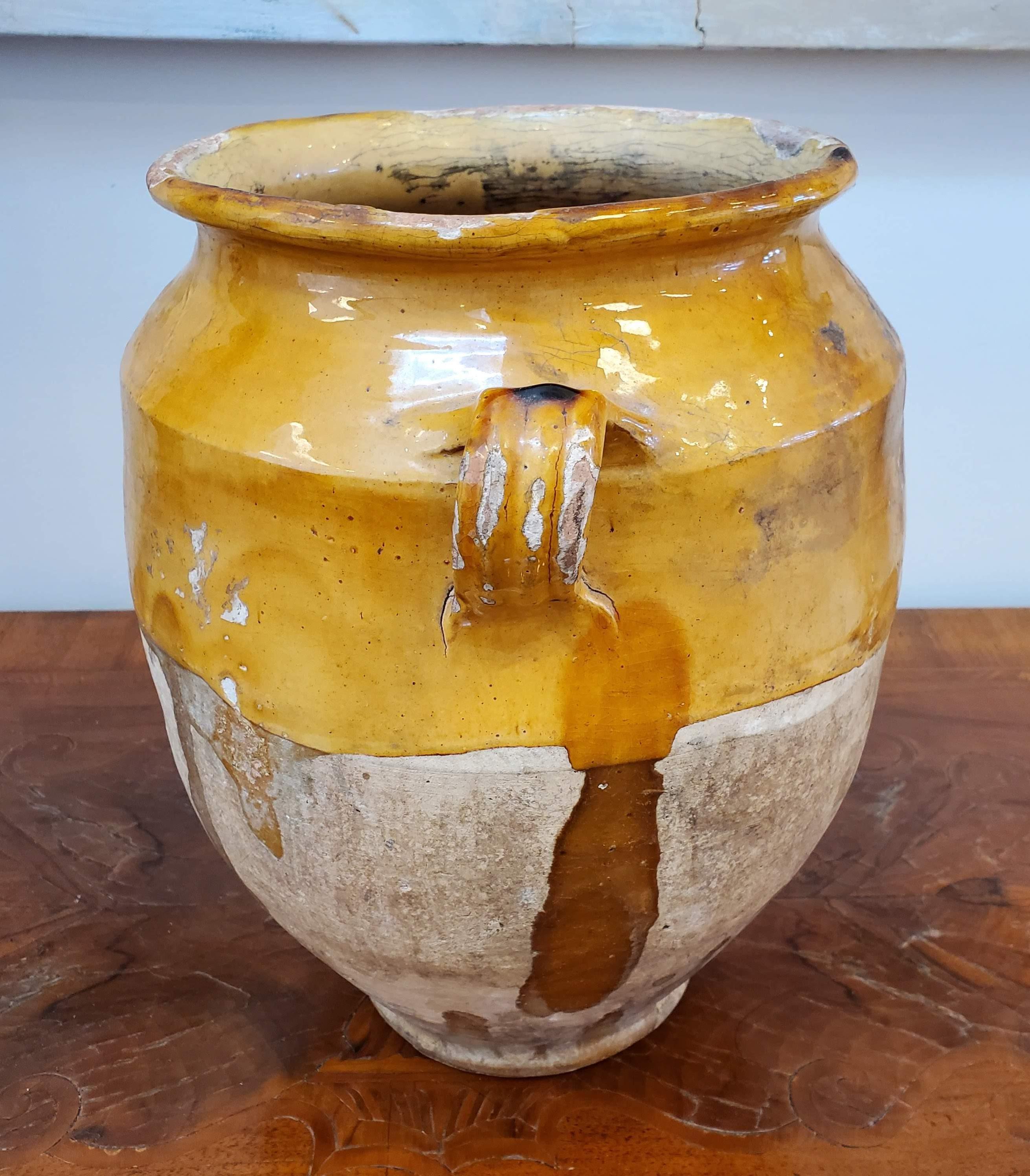 19th century large yellow glazed terra cotta “Confit” pot. Once a staple in French kitchens, confit pots were popular to preserve and cook duck before refrigeration existed. They are also in the featured face in Van Gogh's Sunflower