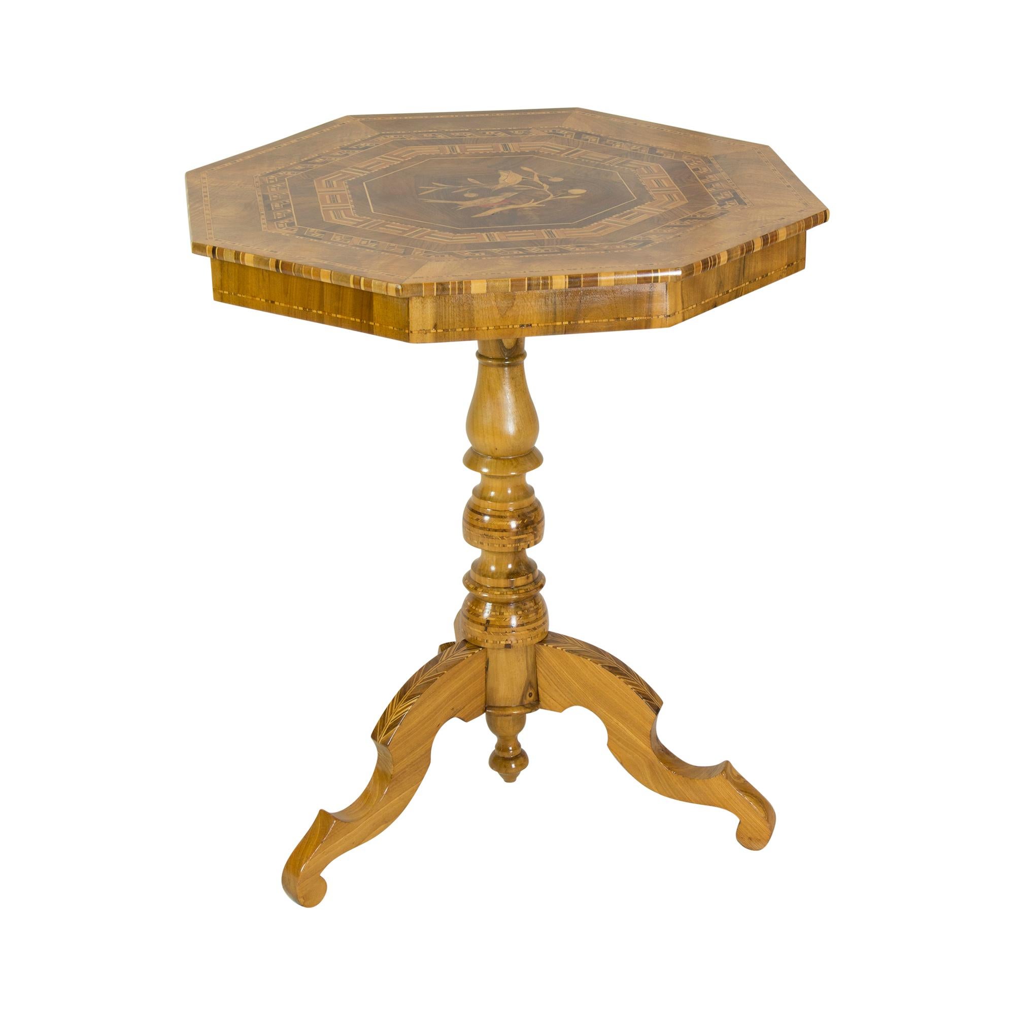 The walnut table stands on a central baluster column, which in turn rests on three outriggers on the floor. On the table top there is a very beautiful inlay work with a picture of two birds. The table has been lovingly restored and is in very good
