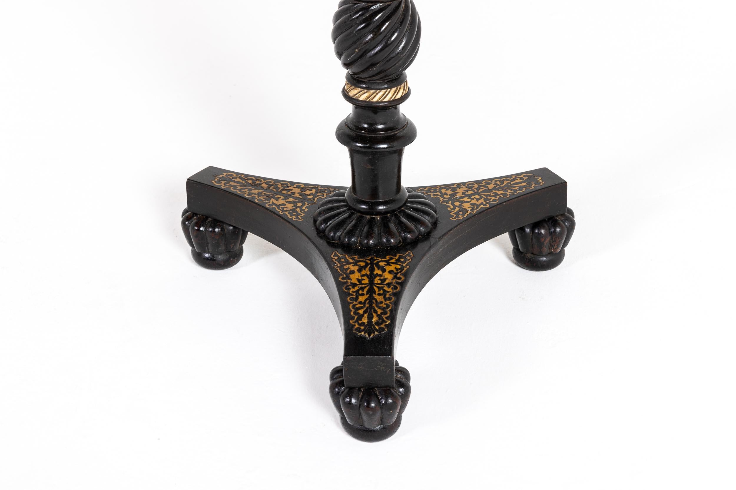 Table de jeu ou d'échecs anglo-indienne en plume d'oie de la fin de la période Regency.

Cette jolie table est ébonisée et décorée de panneaux incrustés dans la base de la plate-forme tripartite et d'un travail à la plume sur le plateau. Soutenu par