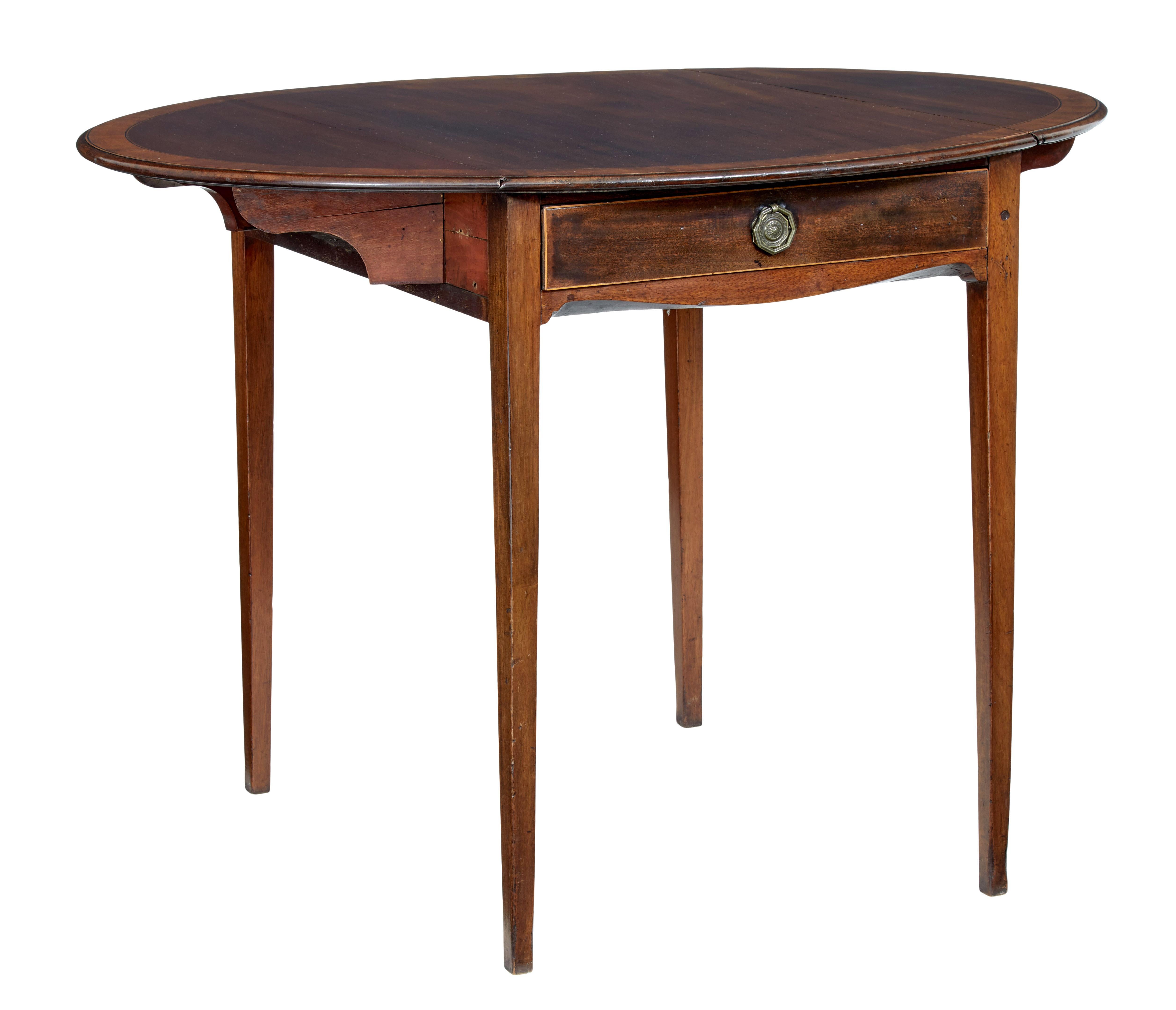 A fine cross banded pembroke table, circa 1825.

Drop leaves open to form a near circular top, mahogany top cross banded and with ebony stringing.

Single drawer to the front with original handle, standing on slight tapered legs.

Minor