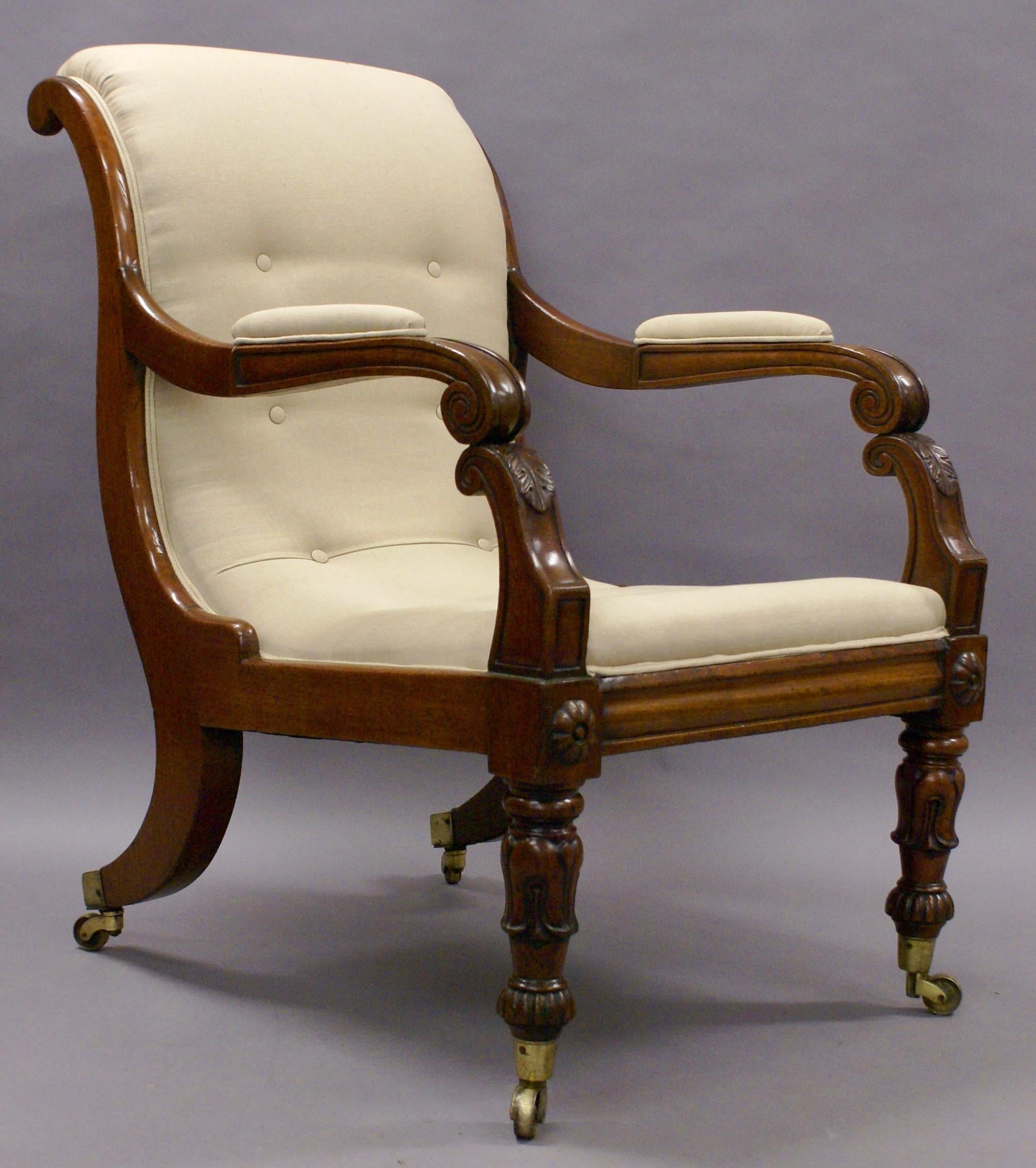 A large later Regency period carved library armchair.
This impressive and elegant armchair is raised on turned and carved front legs and out-swept back legs with original brass castors. The double scroll arms are padded and have carved detail.