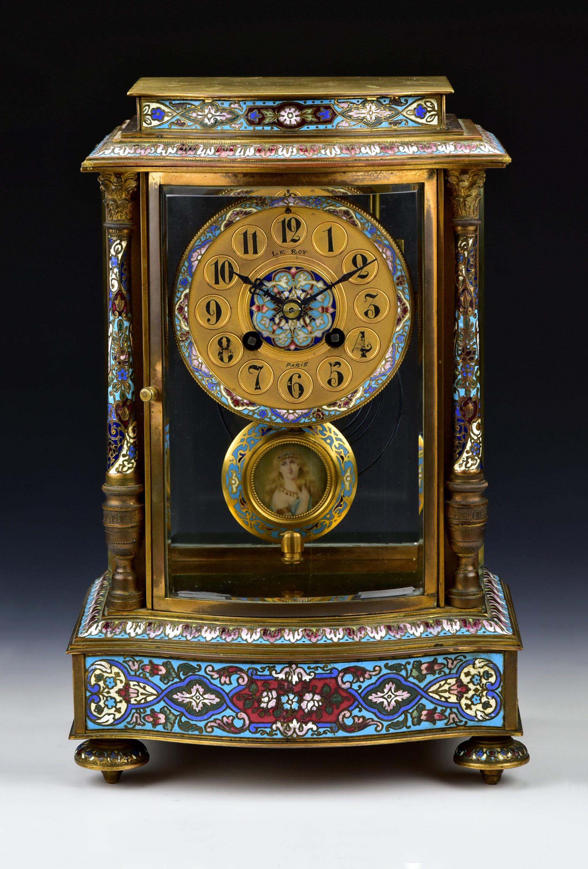 French Champleve mantel clock, gilt bronze body, bowed glass door, champleve decor, and hand painted miniature painting on the pendulum. It runs and chimes once on the half hour and chimes the hour. Marked Le Roy on the dial and Made in France on