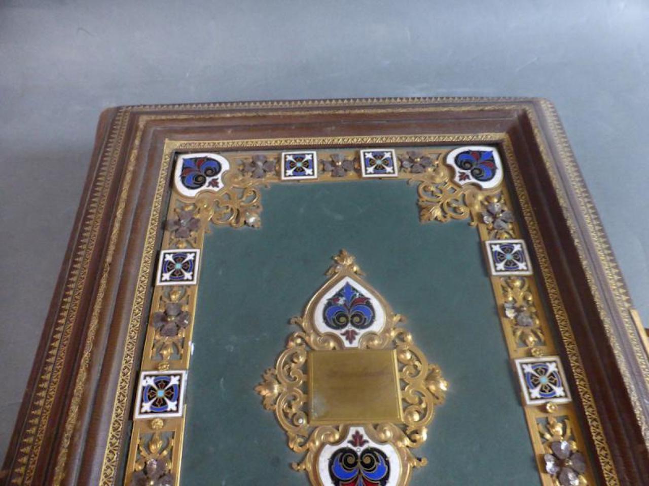 Exceptional leather photo album with openwork gilt bronze decoration and enamelled plaques. 
This album includes sixteen hardback pages that can contain thirty two photos. (note some stains on some pages). The gilding of the edge is in very good