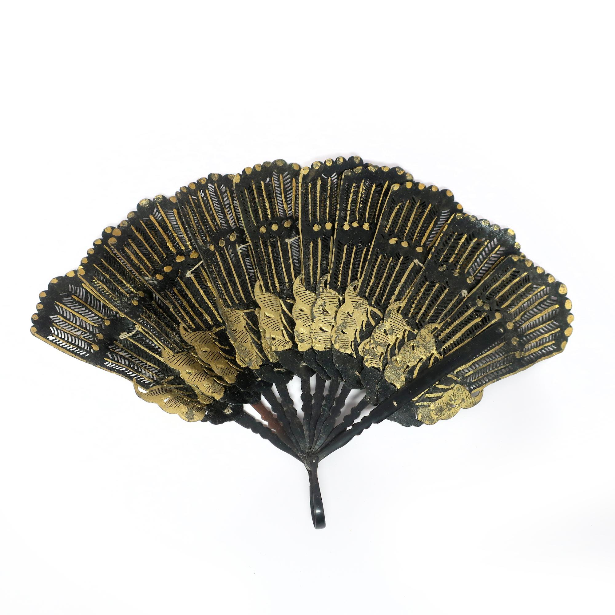 Un superbe et rare exemple d'éventail à main du 19e siècle, en cuir noir et décoré de feuilles d'or. L'éventail est de type brisé, c'est-à-dire qu'il se compose de bâtonnets étroits qui sont reliés au sommet et peuvent être pliés ensemble. Les