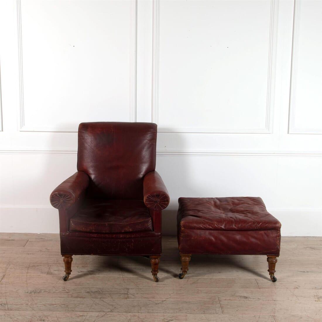 Late 19th century English library armchair and footstool in blonde oak, retaining old red leather upholstery. Mellow, worn and beautiful, circa 1870.

Footstool dimensions: H 44cm, W 69cm, D 69cm.
