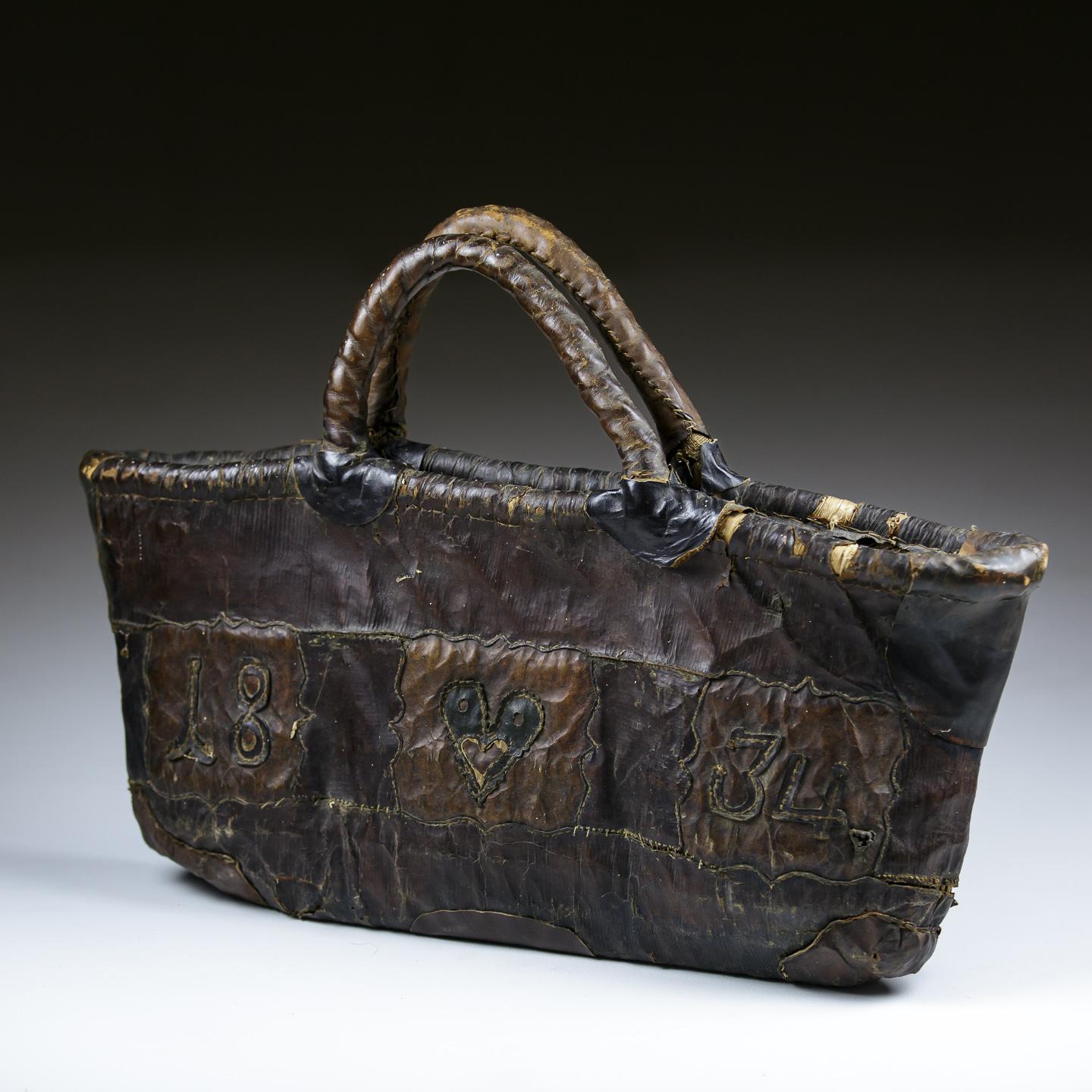 Außergewöhnliche Damenhandtasche aus Leder Love Token, gewebtes Binsenfutter mit appliziertem Leder, zur Herstellung und Verzierung eines Liebesherzens und eines Datums. Mehrere funktionierende Lederreparaturen. Niederlande 1834.
