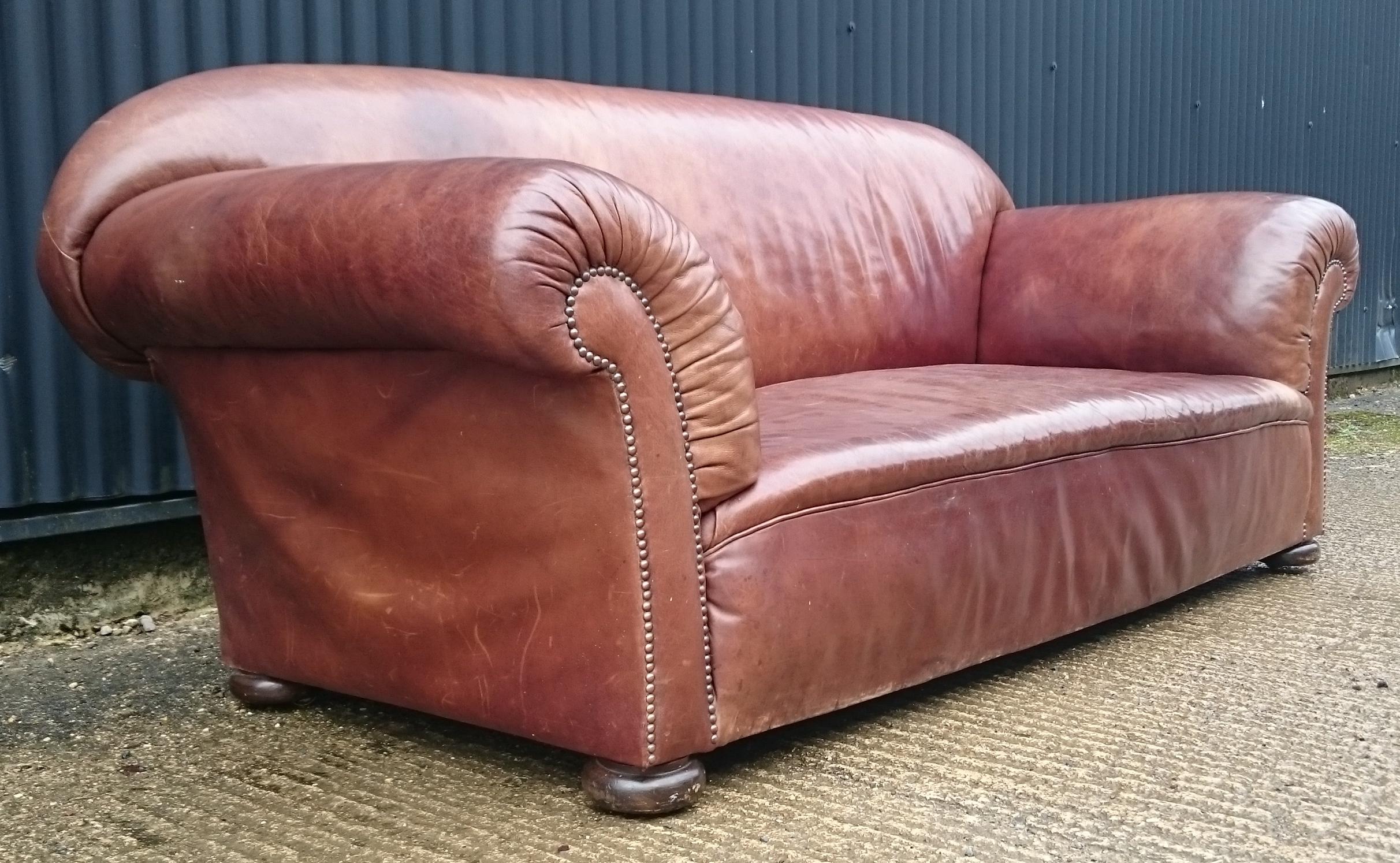 Grand scale 19th century sofa upholstered in leather standing on turned bun feet with brass casters, the back, seat and arms all upholstered in sprung horsehair. The sofa was upholstered in Alma 