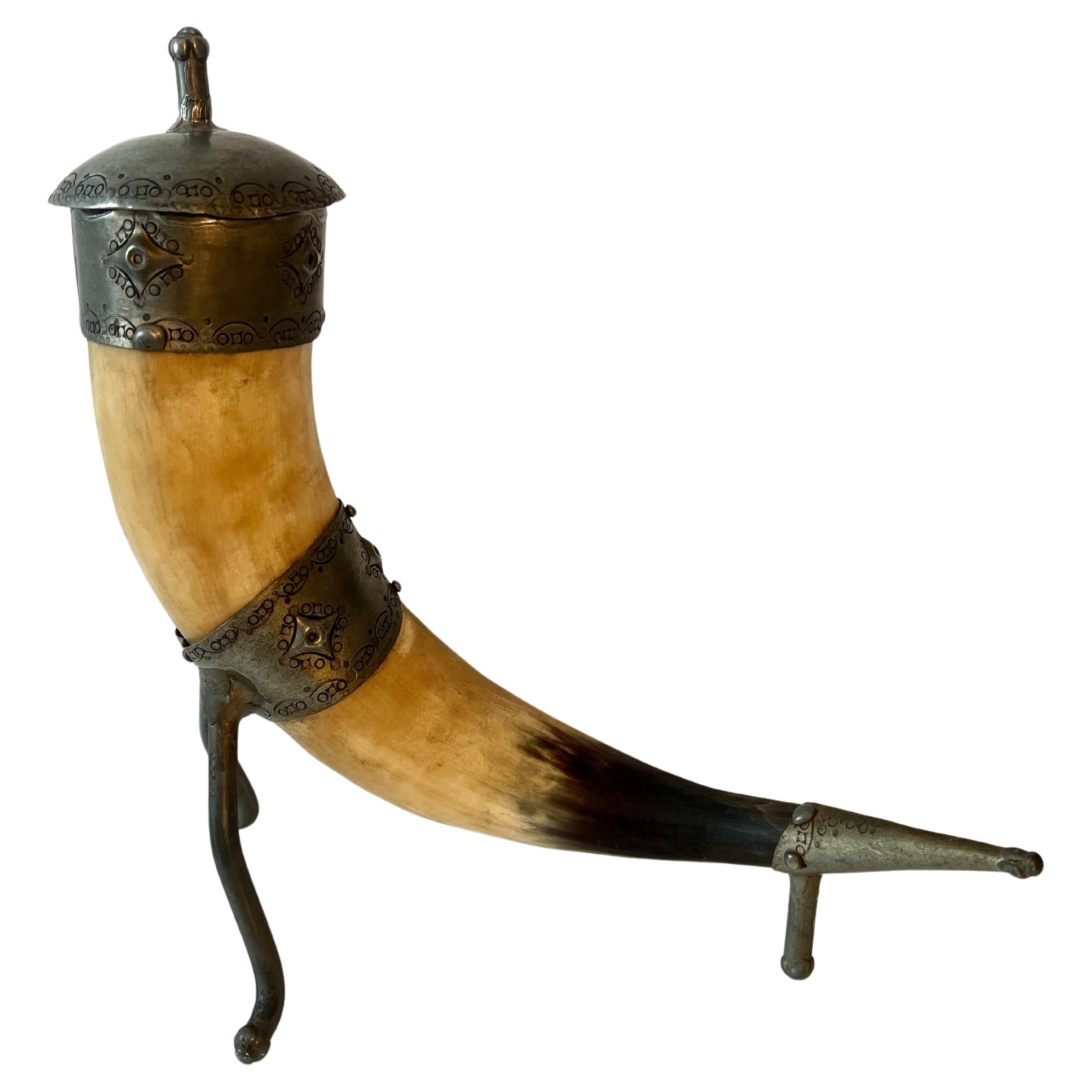 Une magnifique Horn reposant sur trois pieds en étain forgé à la main avec une pointe, un col et un couvercle avec une gravure et des détails travaillés à la main.

Cette corne s'intègre parfaitement à toute étagère ou table console, et plus