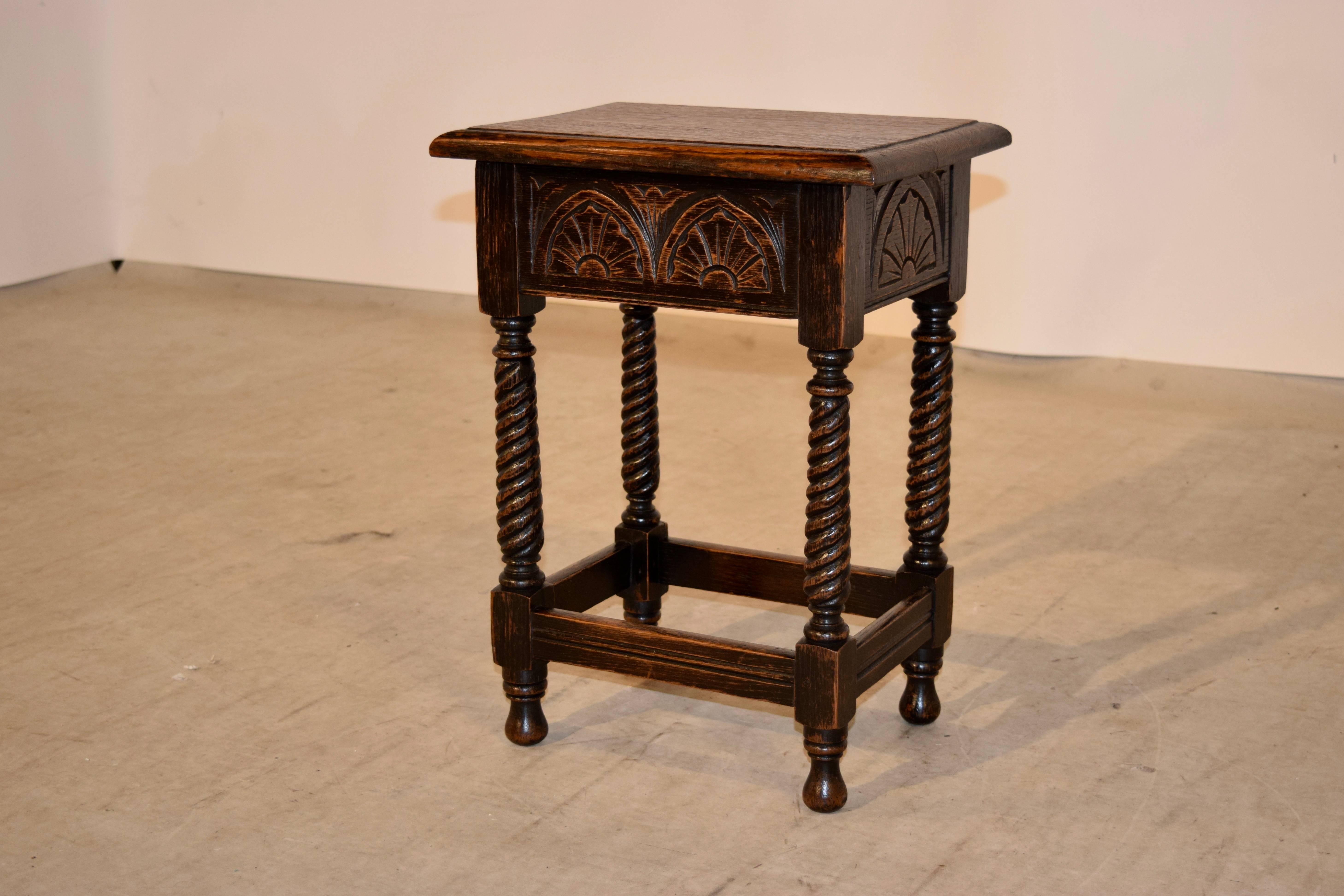 19th century English oak stool with a lift-top for storage. The top has a beveled edge and follows down to a carved apron on all four sides and hand-turned legs which are a lovely twist pattern. They are joined by simple stretchers with routed