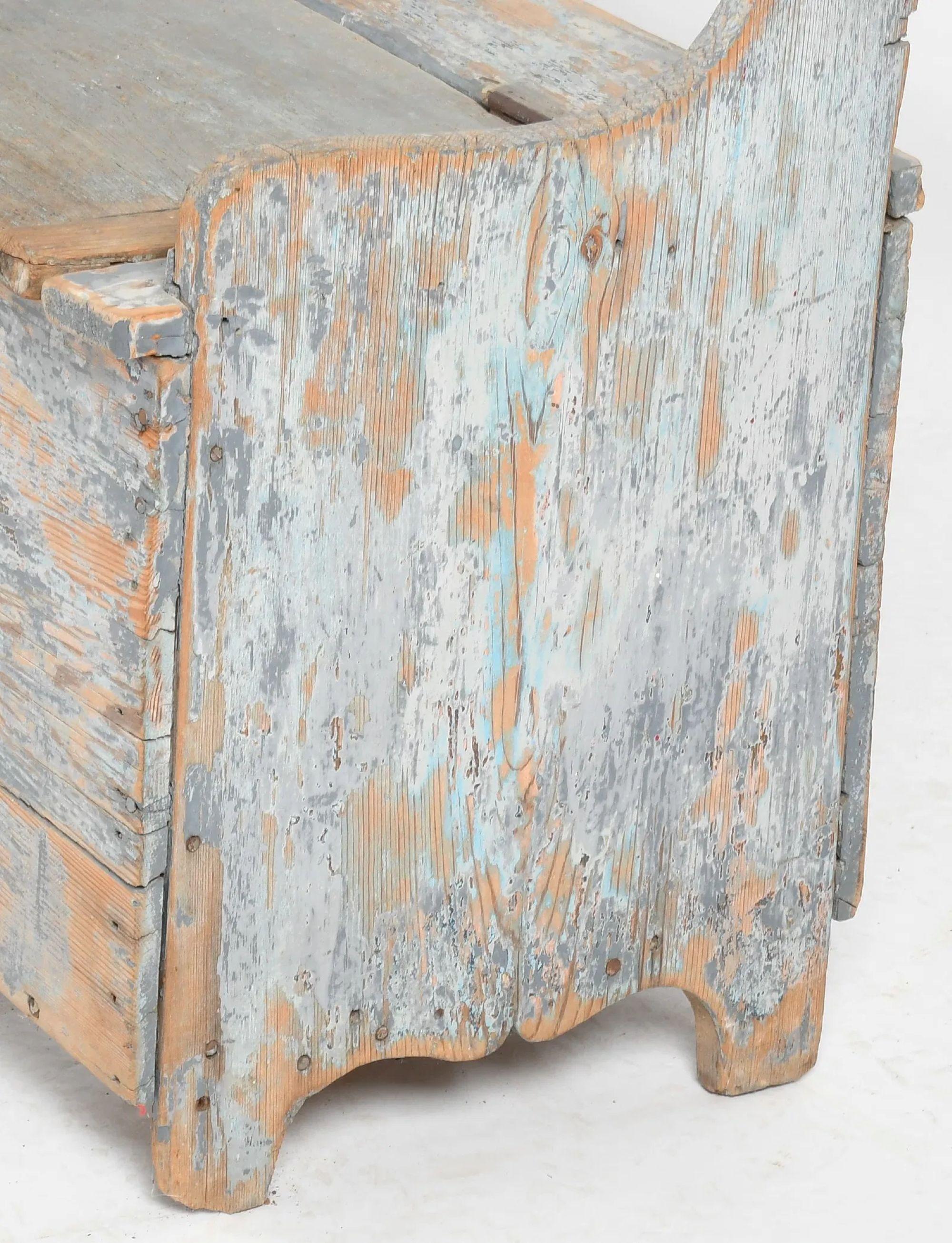 Banc en pin de campagne américain du 19e siècle avec une ancienne peinture de surface bleue naturellement usée.  Le banc est doté d'un dossier ouvert et d'un coffret à deux couvercles à charnières renfermant un compartiment de rangement ouvert. 