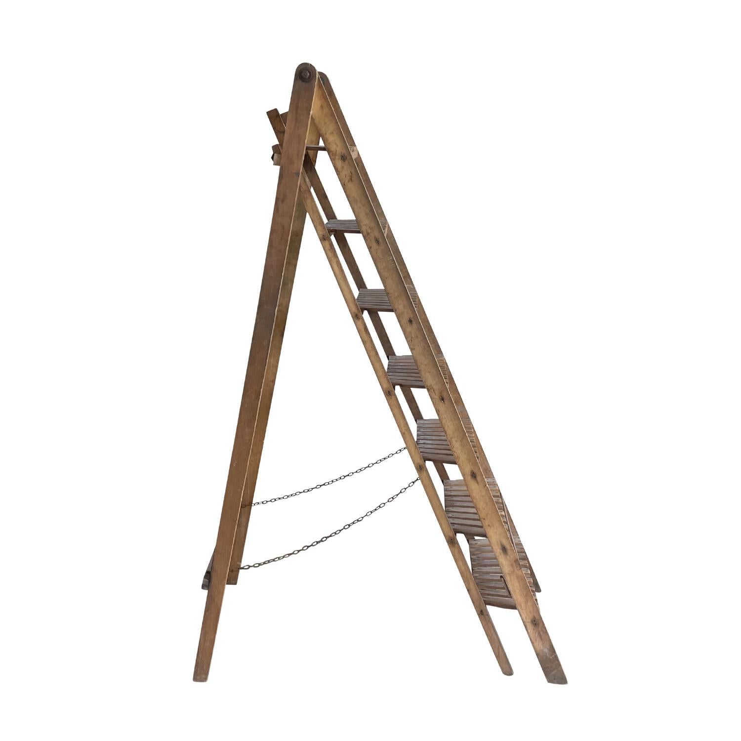 A light-brown, antique French library ladder in a beautiful weathered condition and in good condition. It can be used as a practical piece for your antique library or simply for decoration. Made of hand crafted Walnut wood and easy to fold and fix,
