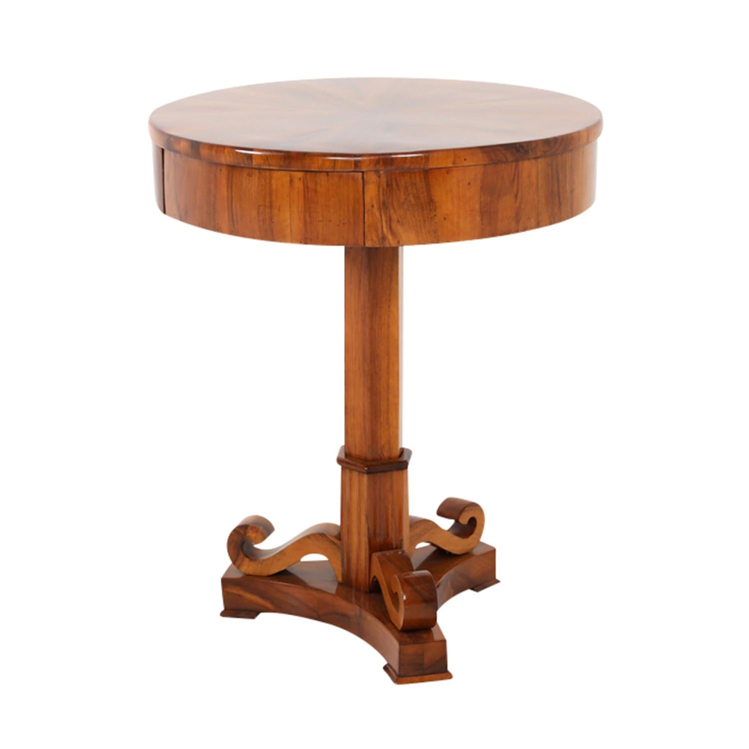 A light-brown, antique German Biedermeier side table made of hand crafted shellac polished, partly veneered Walnut, in very good condition. The small round detailed occasional table is composed with one hidden, pull-out drawer. The end table is