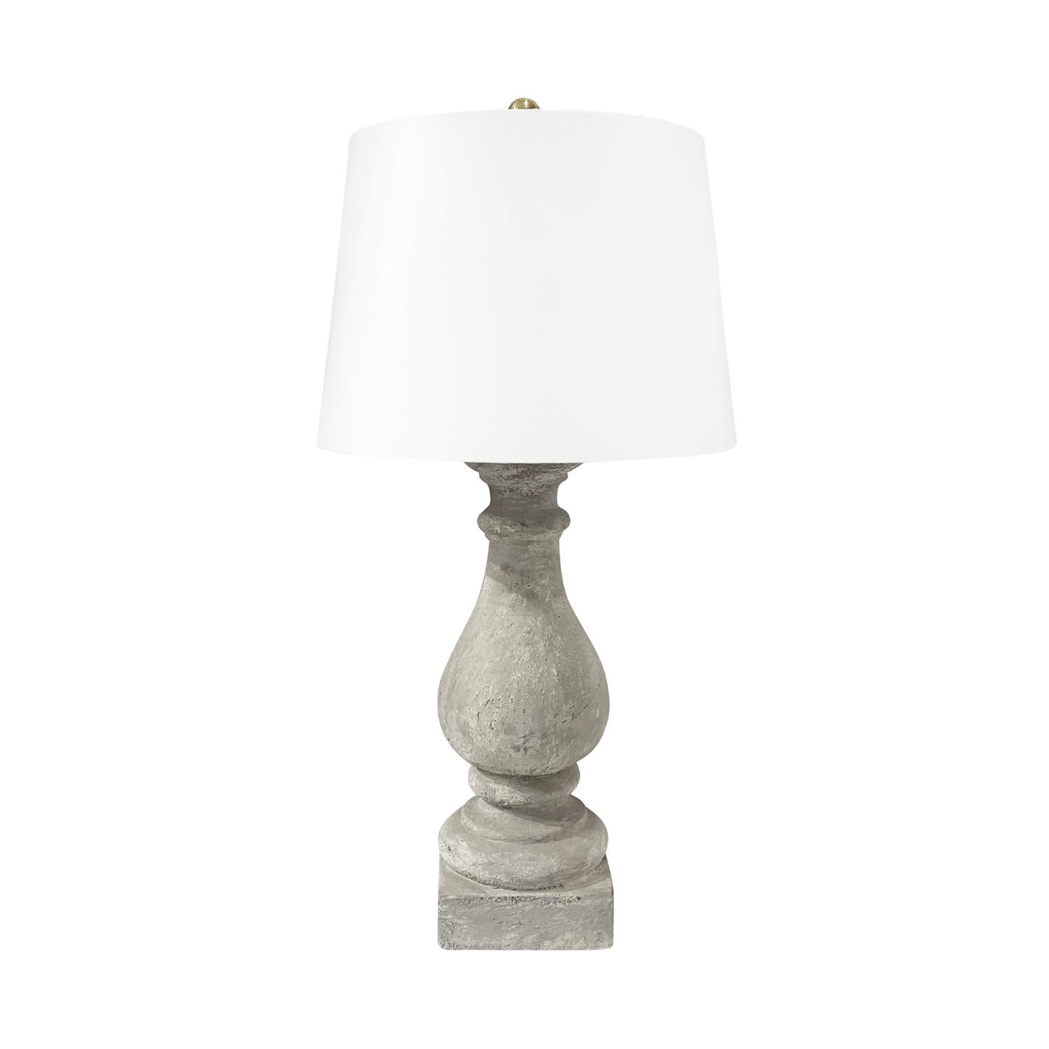 A white-grey, antique French pair of tall table lamps with a new white shade made of handcrafted pièrre composée, in good condition. The lights are detailed with a polished brass ring, featuring a one light socket. The wires have been renewed. Wear