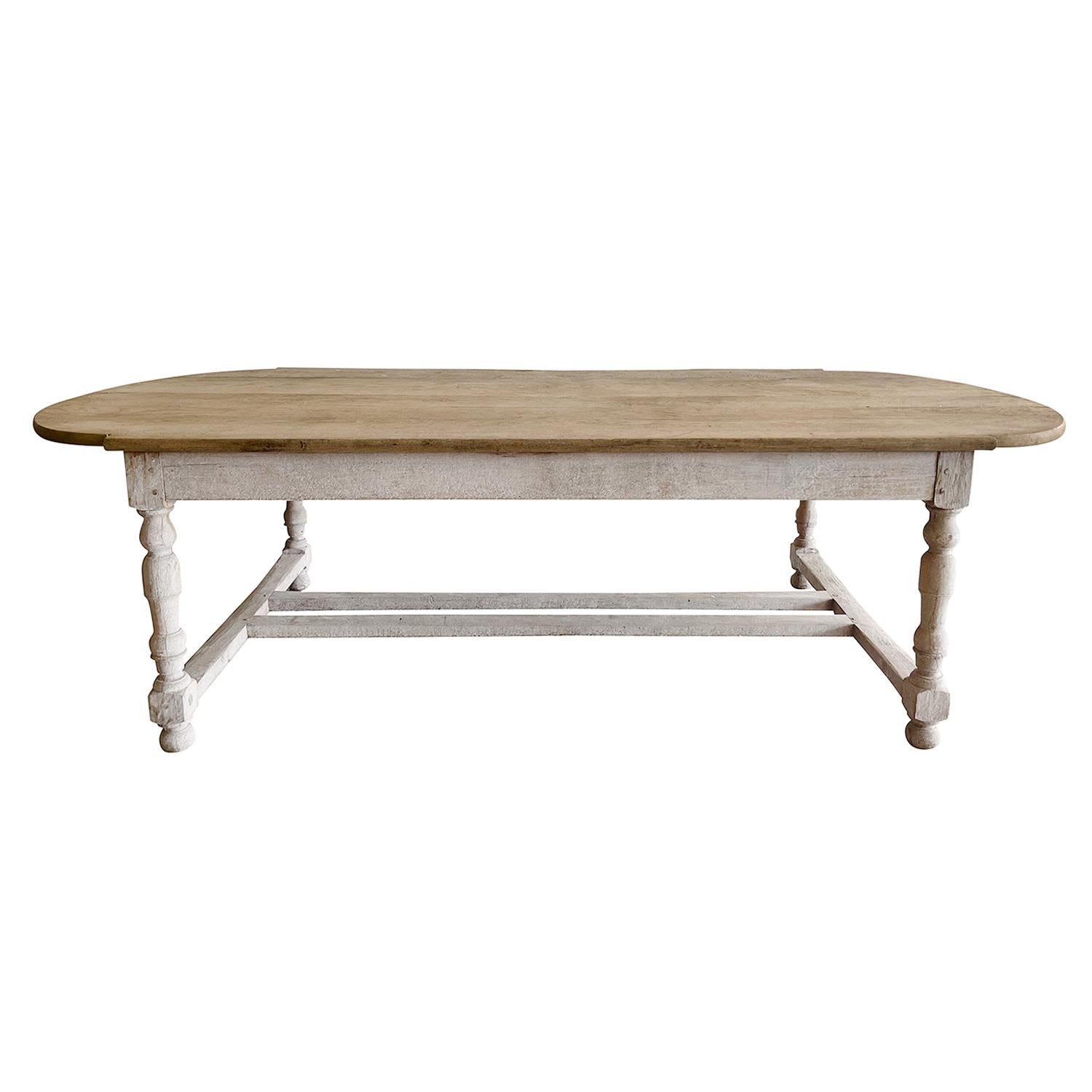 Late 19th century rustic French farmhouse table has an unusual design with center and side stretchers in Beechwood with a white wash finish, in good condition. The table top was hand made using thick planks and the head of the table is of oval
