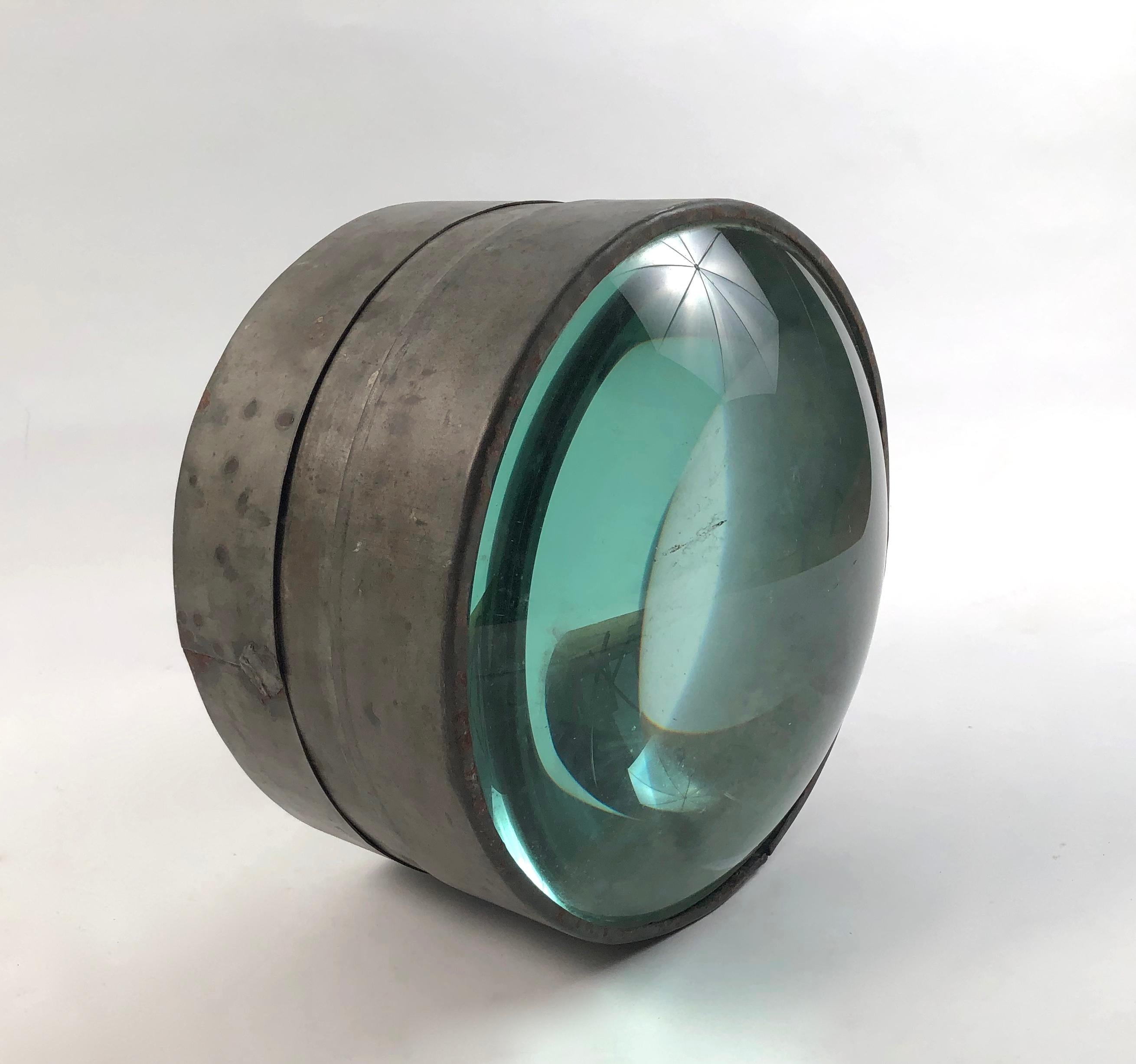 A rare 19th century light house lens, American, circa 1880s, the 2 magnifying convex glass elements contained in a tin or zinc band. This uncommon and beautiful object, both nautical and scientific is a unique tabletop or bookshelf sculpture that