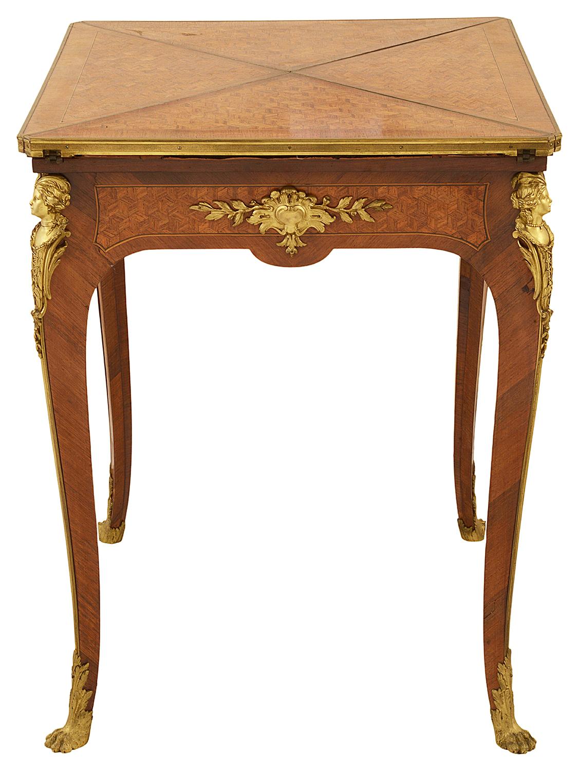 A fine quality late 19th Century French Louis XVI style parquetry inlaid envelope card table. Having wonderful gilded ormolu mouldings, monopodia and claw foot mounts. The quartered hinged top opens to reveal an inset baize covered games table.