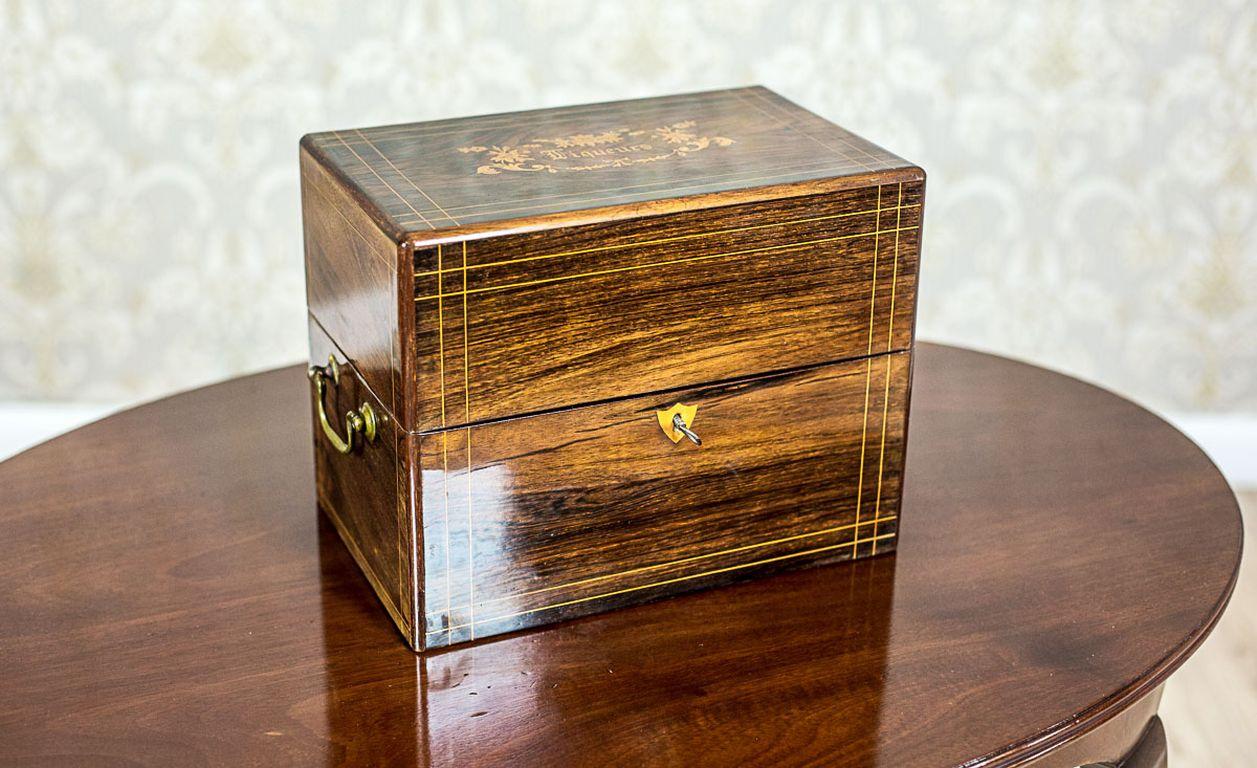 We present you this traveler’s set, circa 1850, intended for storing liqueurs; with three decanters and four glasses.
The set includes a wooden storage box in rosewood veneer, with an intarsiated lid, and fillet stripes around.
Furthermore, the