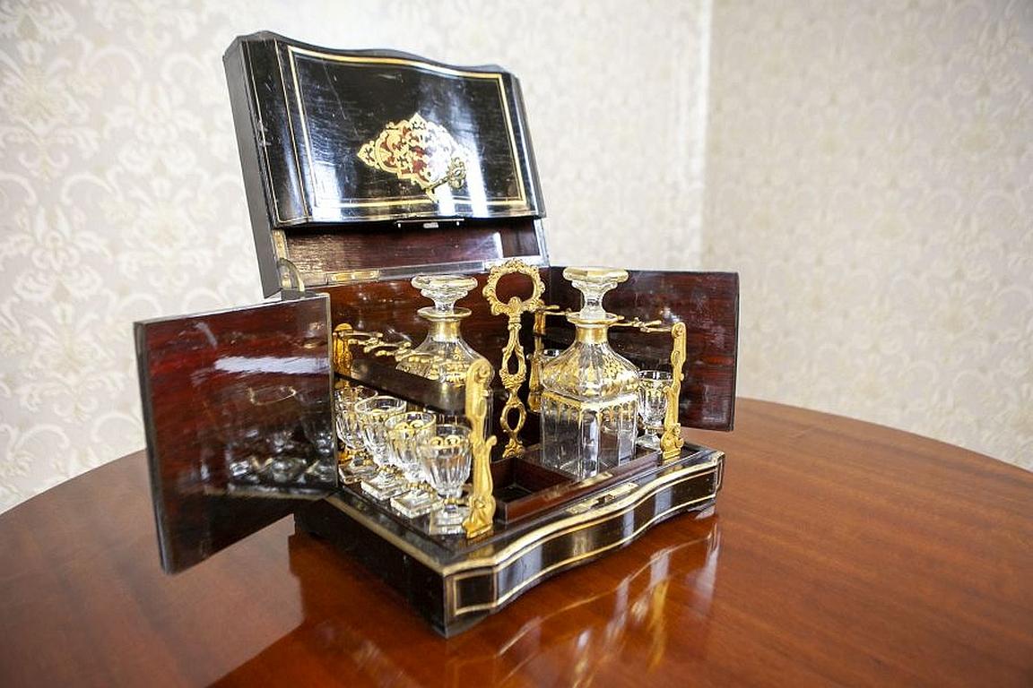 19th-Century Black Rosewood Liquor Case in the Style of Napoleon III

We present you this set (incomplete) composed of two decanters and eight glasses. All is hidden in a rosewood case with openable leaves, which is decorated with marquetry and