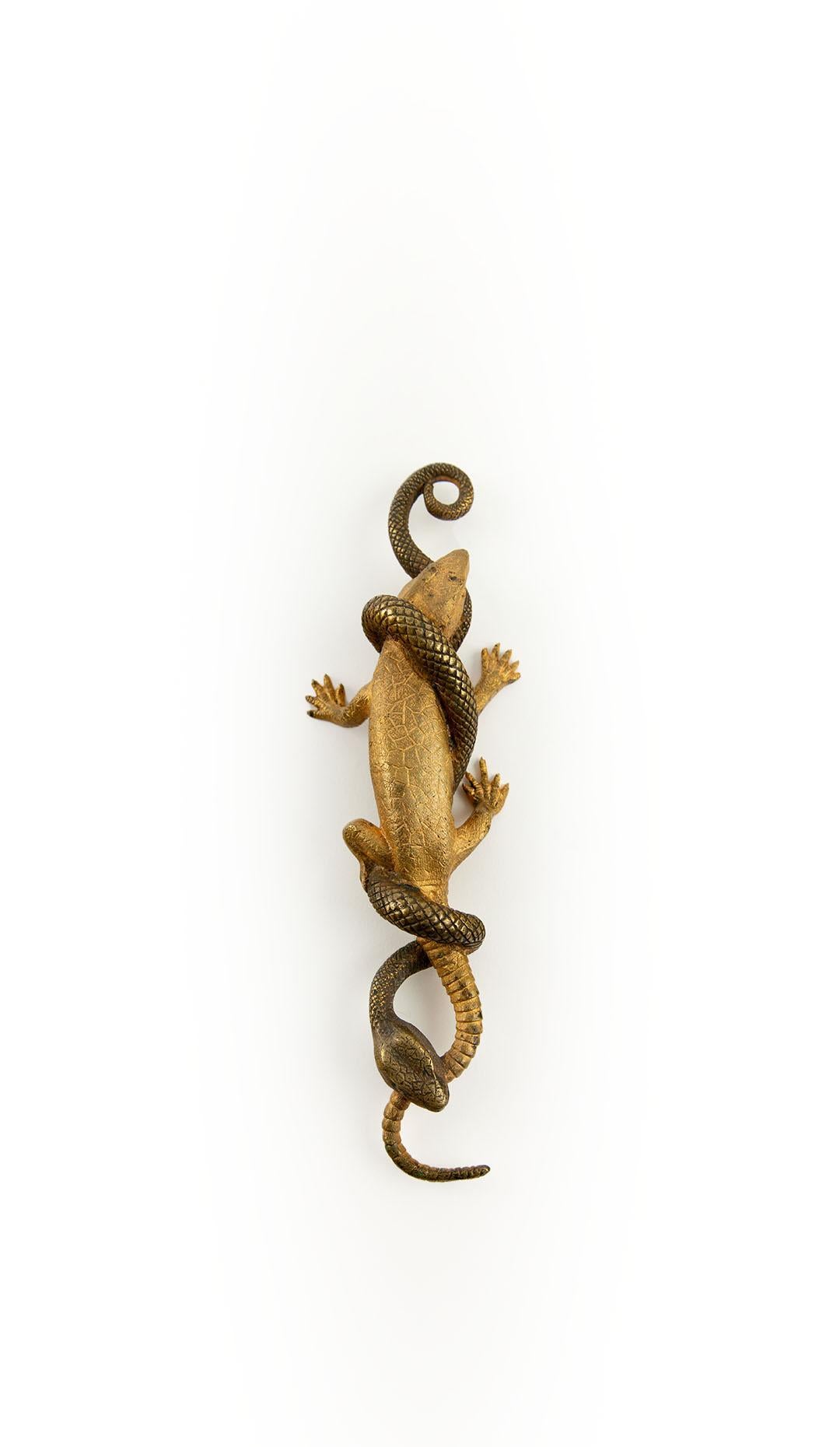 Sculpture exquise et dynamique en bronze doré du XIXe siècle représentant un serpent enlacé autour d'un lézard en plein combat. Cette pièce finement moulée et détaillée capture la tension et le réalisme de la nature en mouvement, avec une texture