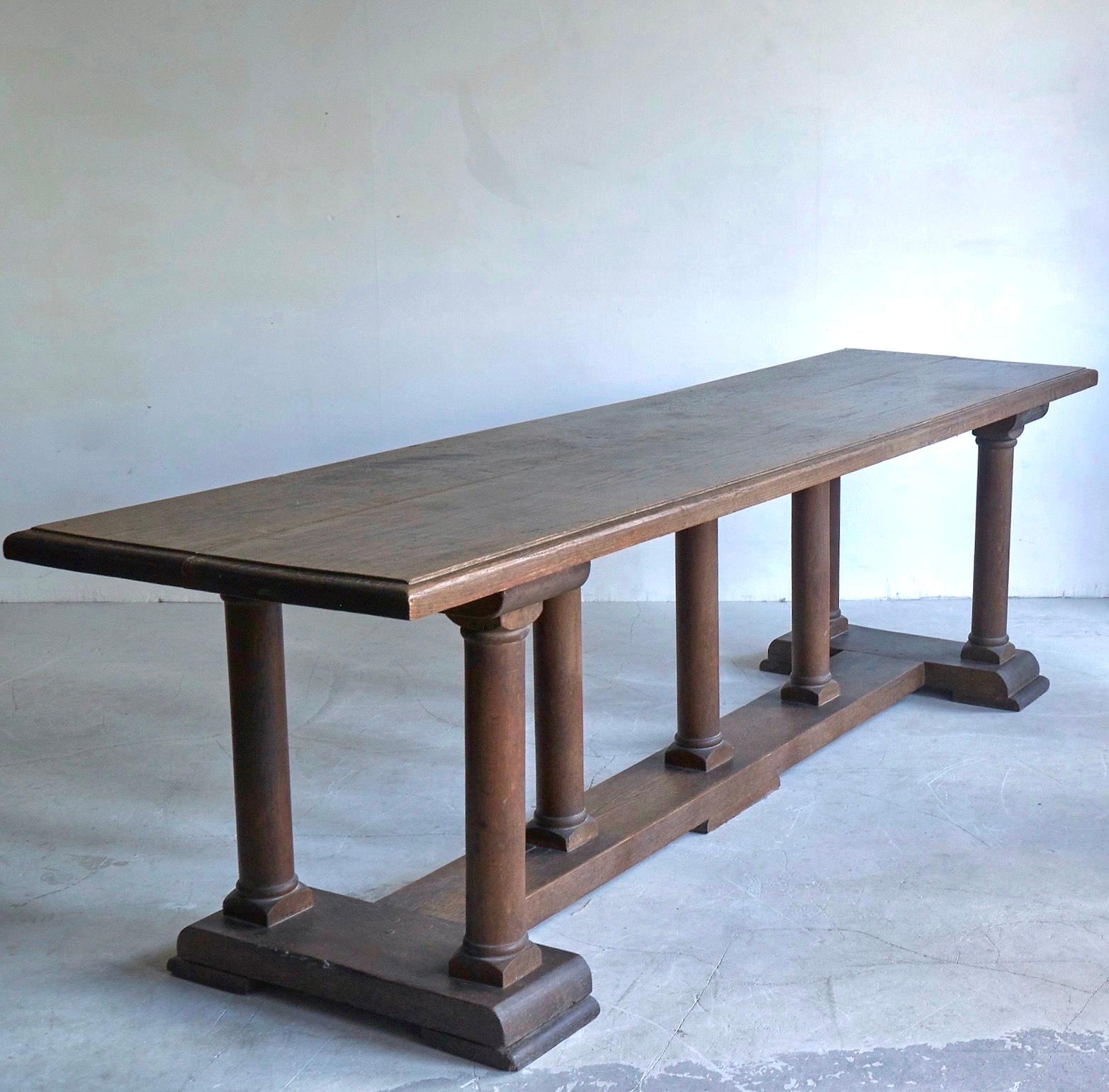 A 19th Century Oak table, with a 2 inch thick top and simple moulded edge, architectural in design the piece stands on 7 straight columns with a square base and curved corners. It has a lovely dry condition but could also be waxed up beautifully. A