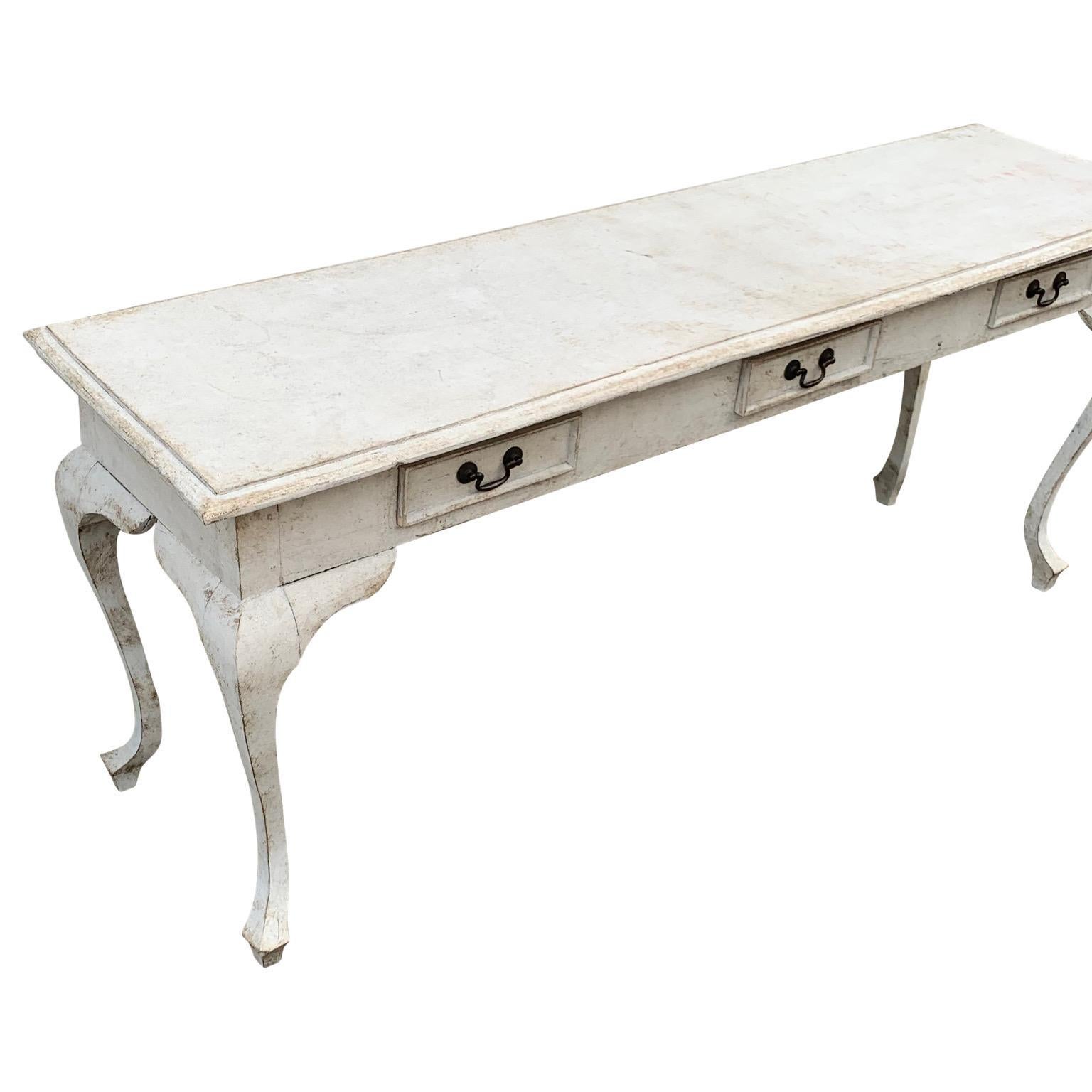 This impressive hand painted console or foyer table with three drawers features wonderful classic details, such as the cabriole legs. The table has been painted in a light gray Gustavian color called Gustav. This grey table certainly brings vintage