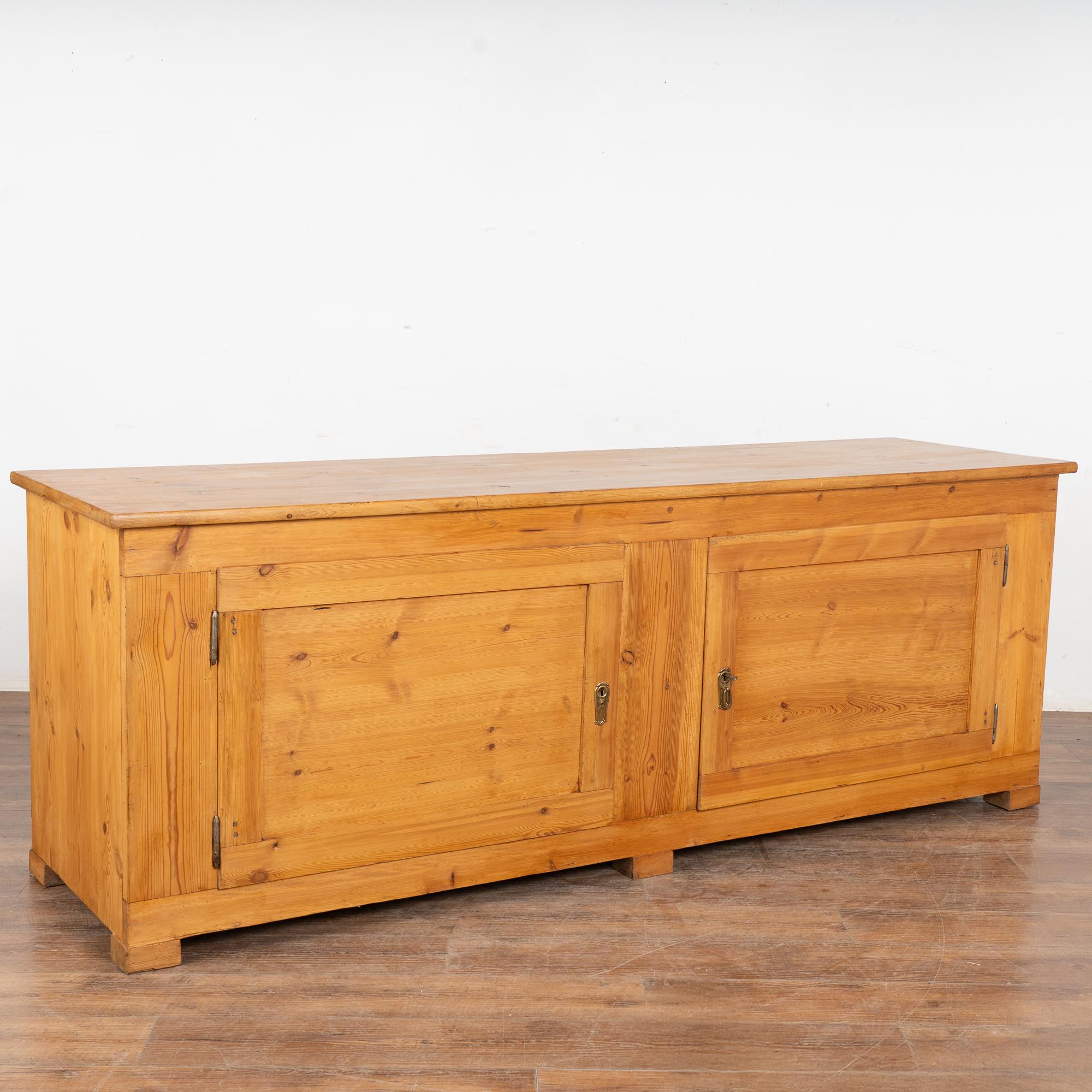 This Swedish pine sideboard is just over 7' long and maintains its simple country charm with a waxed finish on the natural pine.
The interior reveals a single shelf which runs continuous left to right (no central divider).
Restored, strong, stable