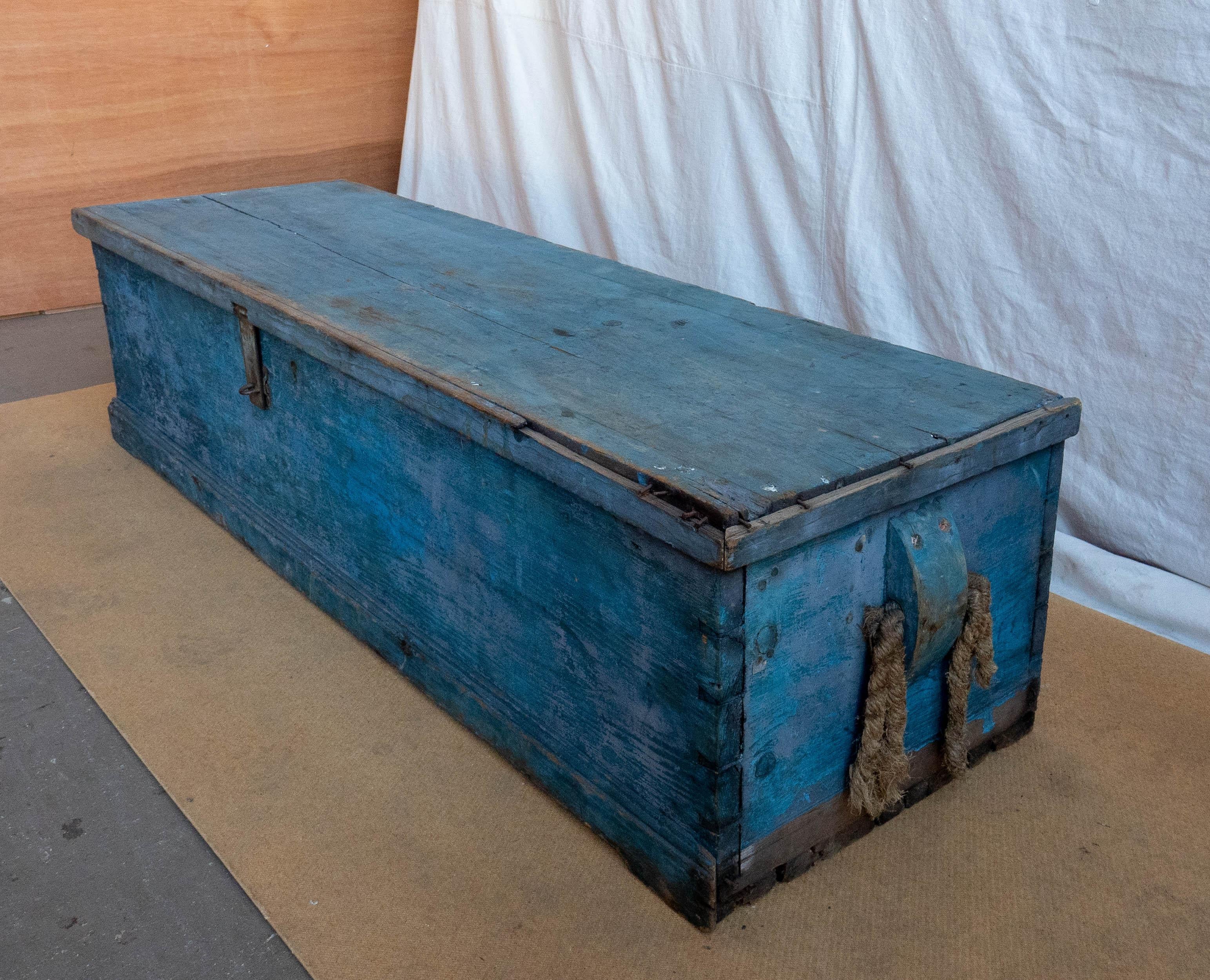 19th century long sea chest in sky blue paint, the rectangular top having applied lip, above dove-tailed case with carved wooden beckets holding the frayed remains of the original spliced rope handles, in very old sky blue paint. Unusual sized sea