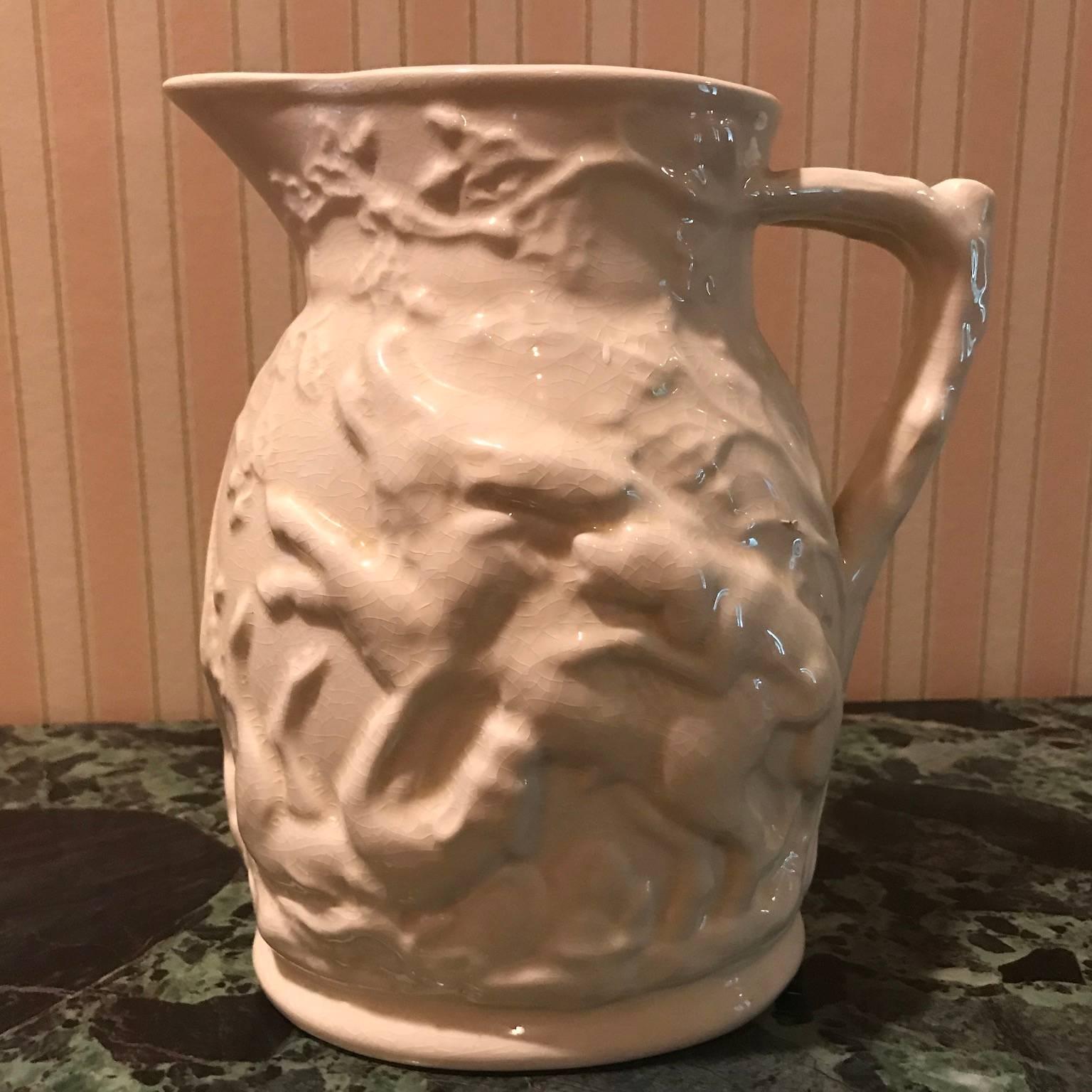 Lot of four porcelain relief pitchers, each decorated with scenes. Measures: 1). 8