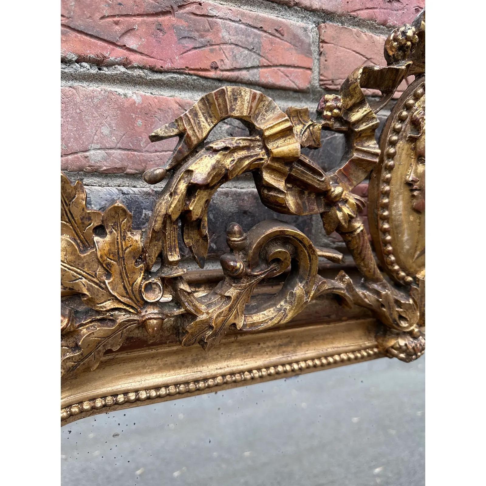 This 19th Century French mirror is top of its class! With its stunning gilded adornments such as its hand carved edging, ornate cartouche, and oversized silhouette, this mirror is bound to make a grand impression in any space. It has all of its