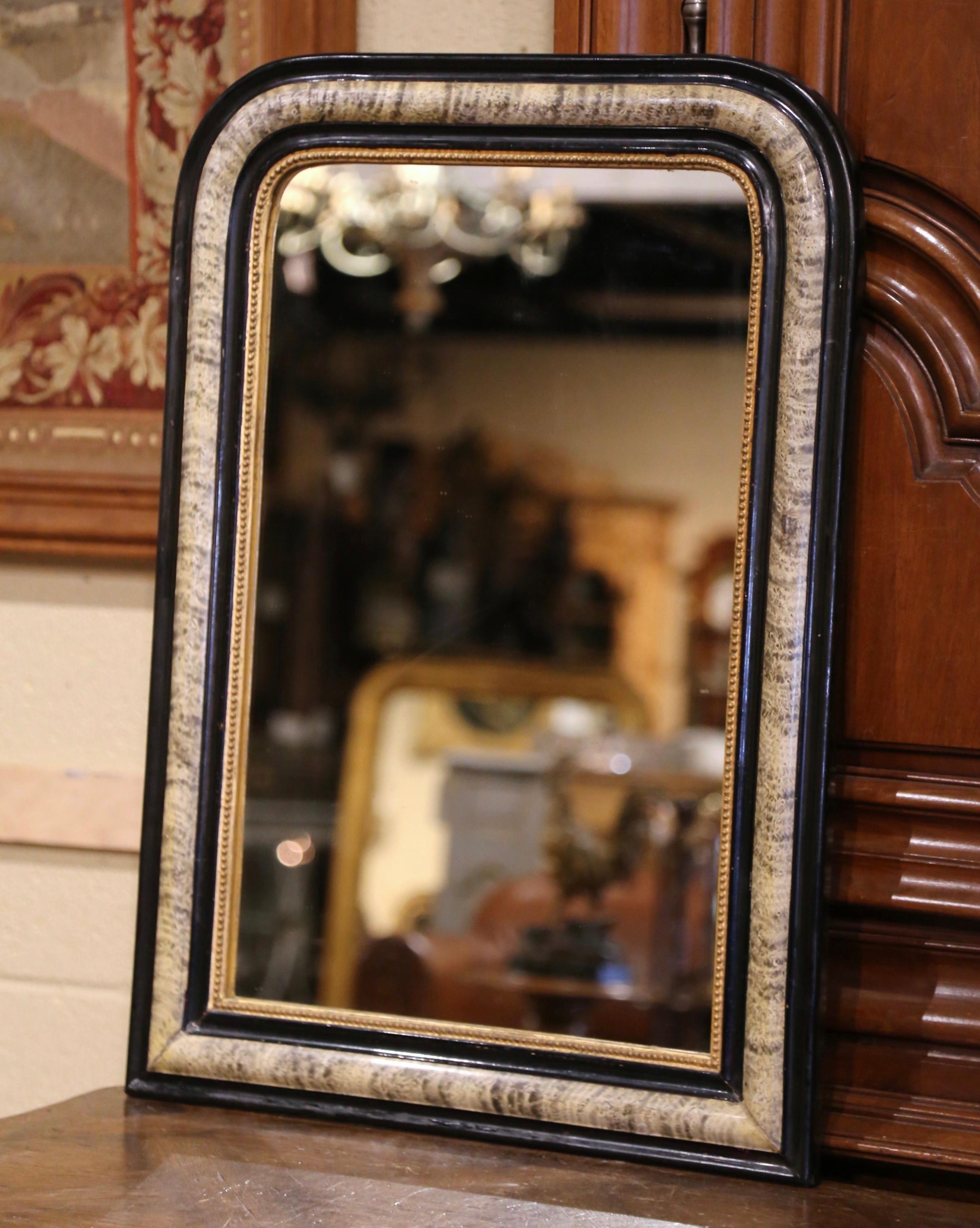 This elegant antique wall mirror was crafted in France, circa 1870. The frame is decorated with a Faux Bois painted decor in between patinated blackened paint finish; it is further embellished with carved beads around the inside edges. The