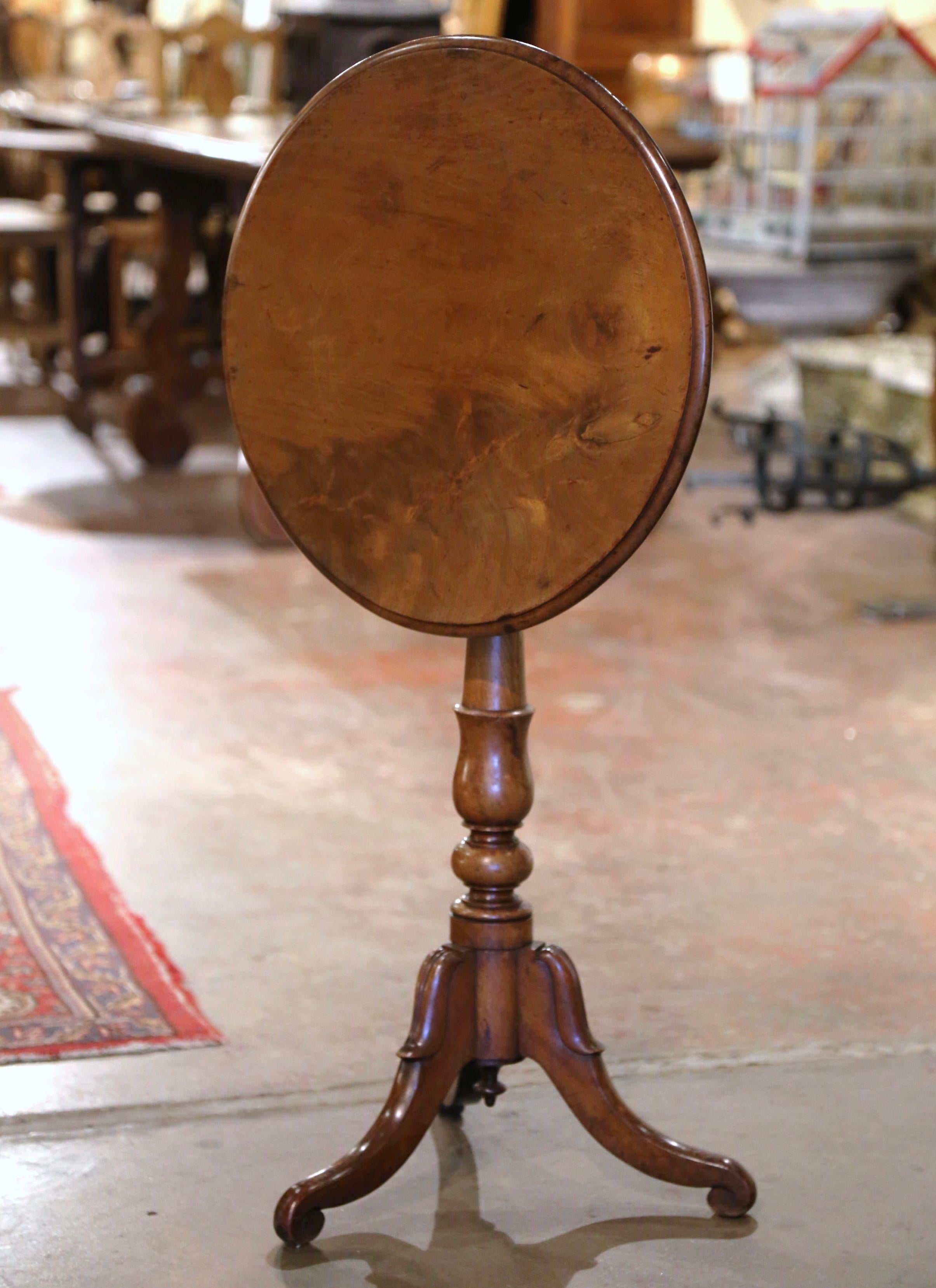 This antique fruit wood pedestal table was crafted in France, circa 1880. Standing on three scroll feet decorated with acanthus leaf motifs over a carved turned stem, the gueridon is dressed with a round tilt top surface built with one piece of