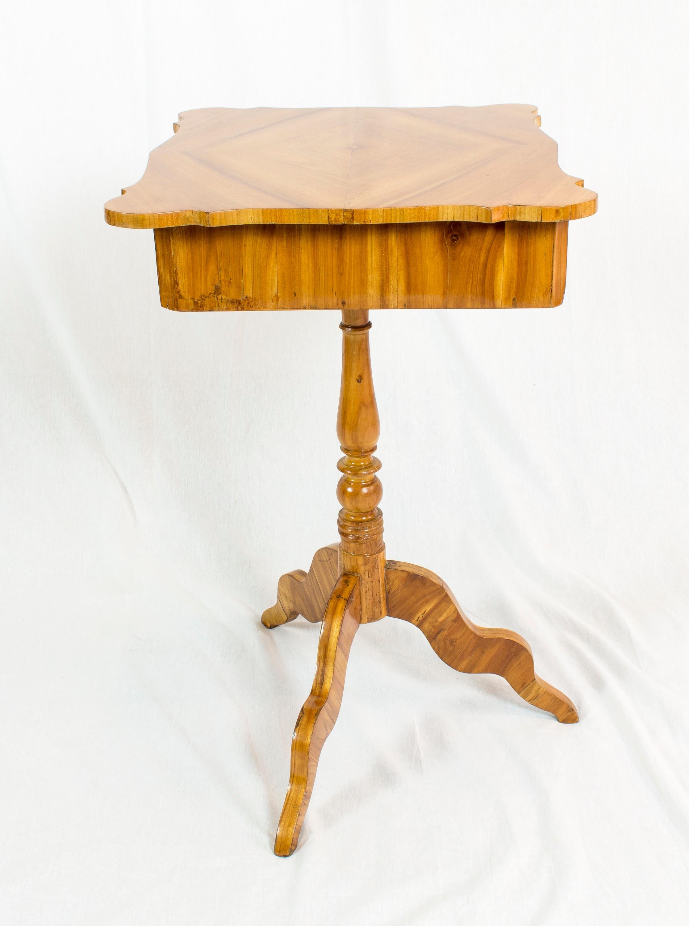 Magnifique table de couture ou d'appoint en placage de bois de cerisier sur un corps en épicéa. La table date de la période Louis Philippe / fin Biedermeier, plus précisément de l'époque, vers 1845. En très bon état restauré.