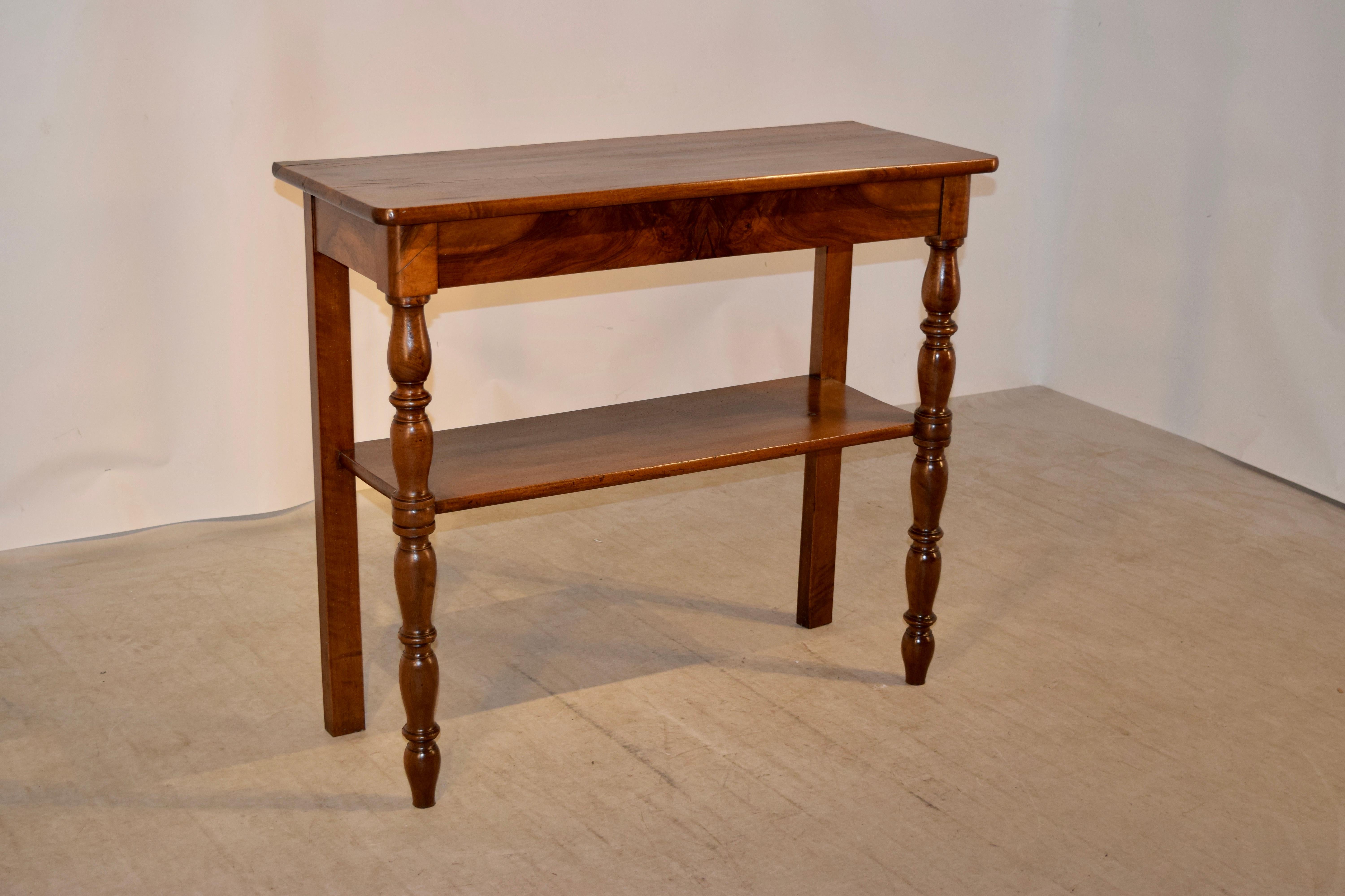 19th century Louis Philippe console made from walnut. The top is wonderfully grained and has shrinkage from age. This follows down to a simple apron and supported on hand-turned legs in the front and simple legs in the back for easy placement