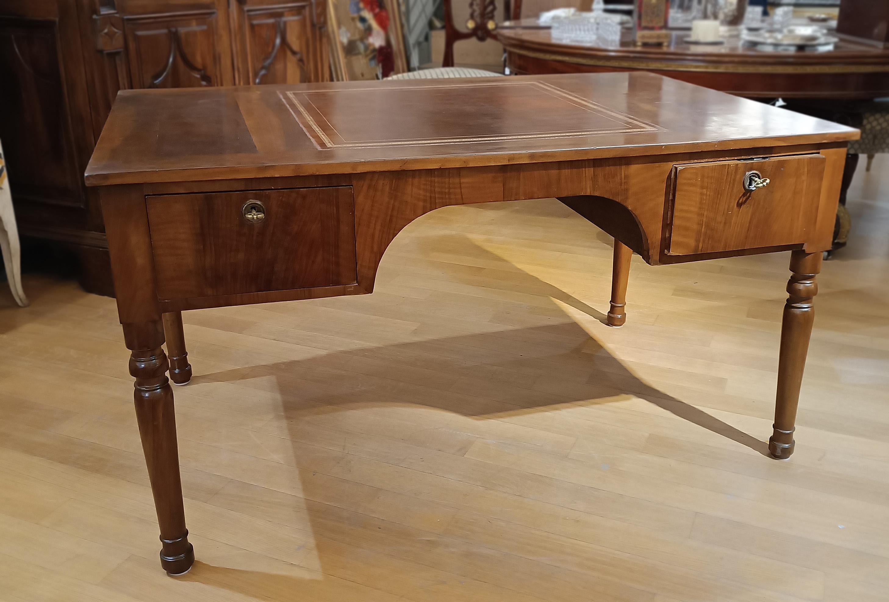 This desk is a refined piece of furniture made entirely of solid and feather walnut. The table top is embellished with a gold and leather finish that adds a touch of luxury. The surface is also spacious and perfect for working or studying. The
