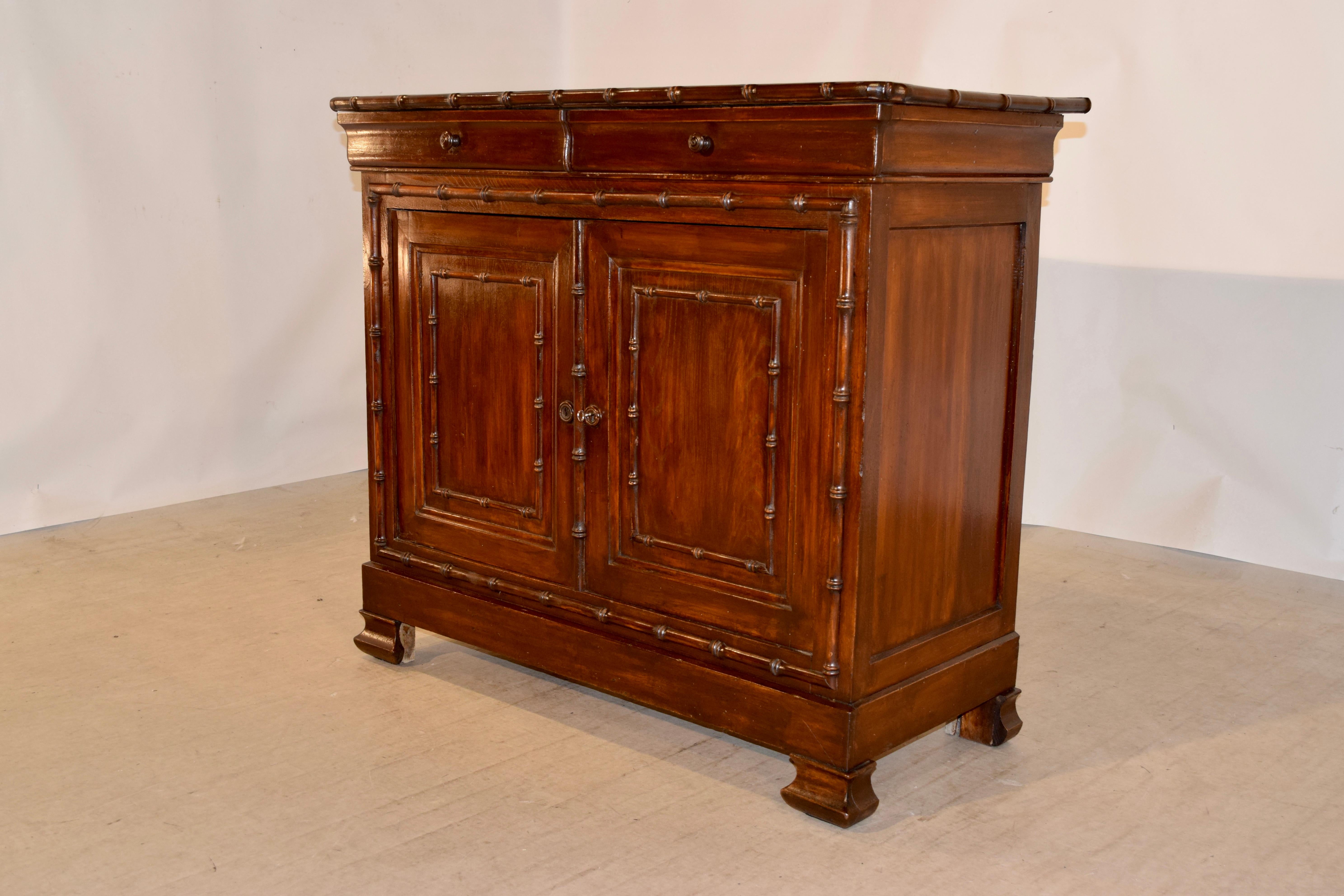 19th century Louis Philippe enfilade with faux bamboo molding. The top has chamfered corners and is surrounded by faux bamboo turned moldings, following down to a simple case with simple sides and the front containing two shaped drawers over two