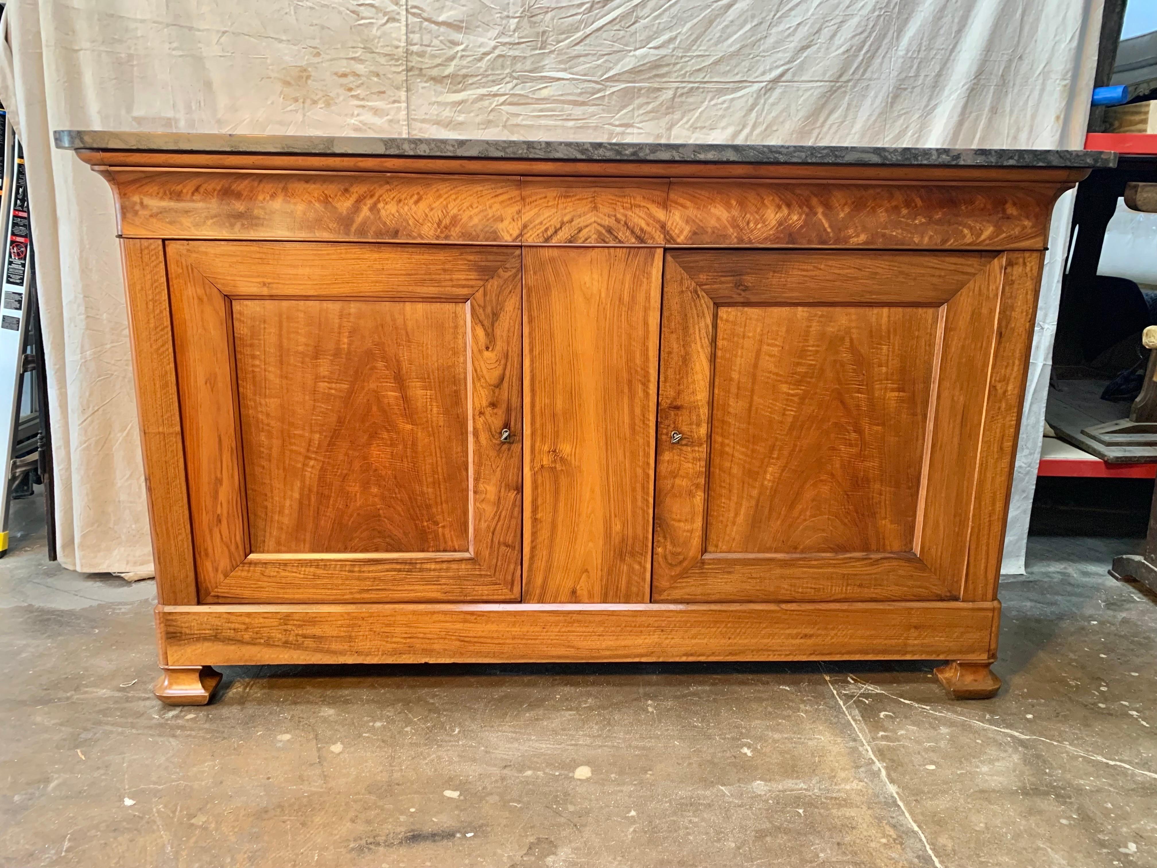 Found in the South of France, this French Louis Philippe buffet or sideboard, was crafted from old growth walnut and retains its original marble top. The marble top features a variety of grays with a beautiful white veining creating a unique color