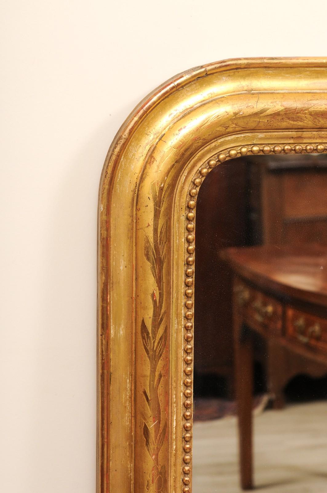 Bellissimo specchio d'epoca in legno dorato di Louis Philippe con dettagli floreali e foglie intagliate lungo la cornice. Vetro originale e tavole di pino sul retro dello specchio.