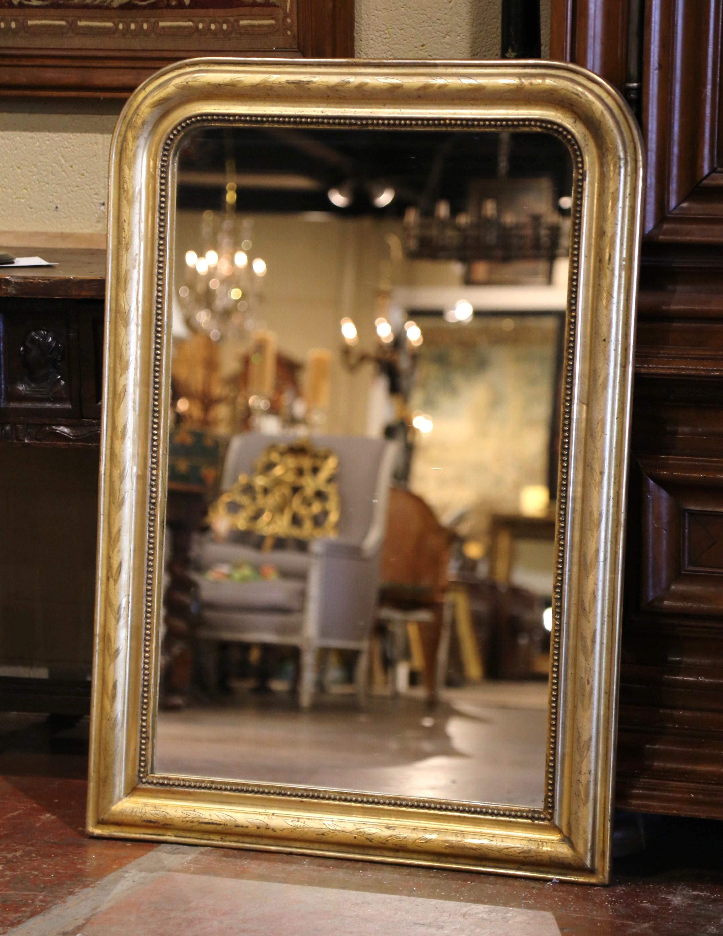 Decorate a bedroom, powder room or entryway with this elegant antique mirror. Crafted in the Burgundy region of France circa 1860, the large gilt mirror has traditional lines with rounded corners; the rectangular thick frame is decorated with a