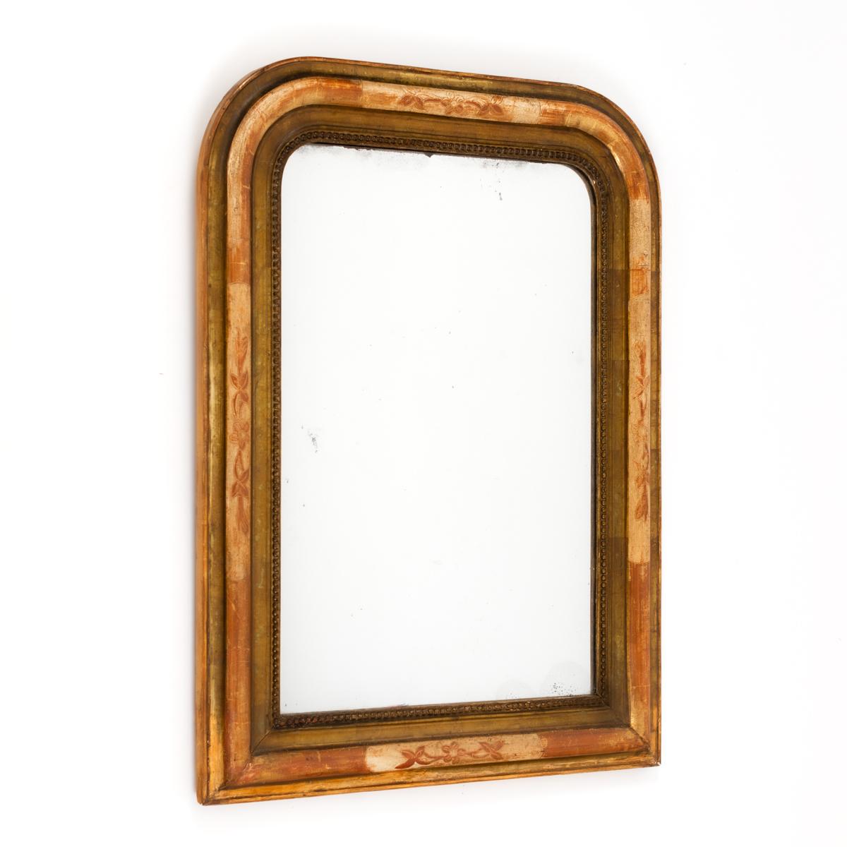 Antique French Louis Philippe mirror with curved upper corners, gilded and patinated frame in golden beige brown-red.
Original mercury glass and wooden back, circa 1860.

The mirror has a profiled frame which has engraved stylized flowers and leaves