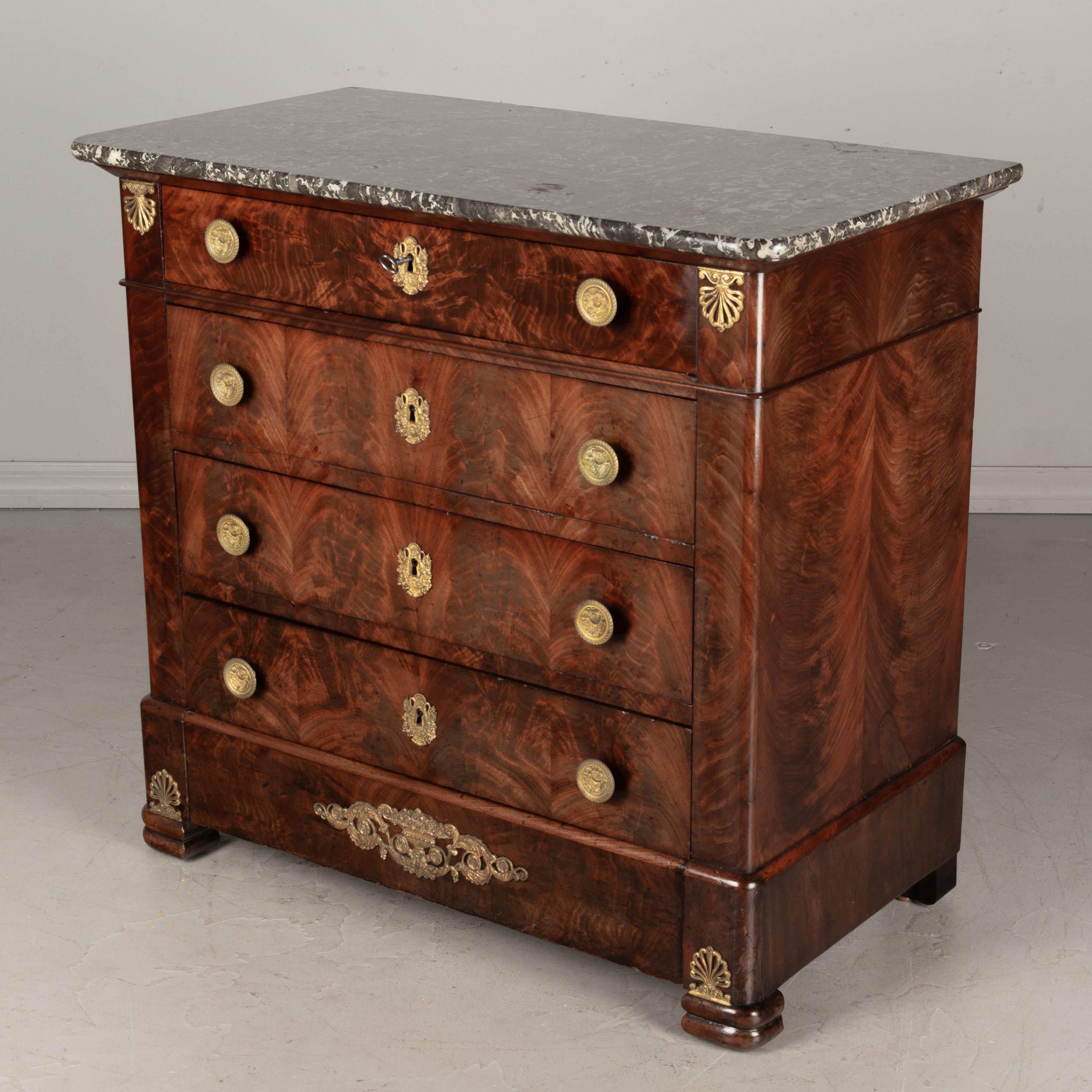 An early 19th century French Louis Philippe Period mahogany four-drawer commode, or chest of drawers. Fine craftsmanship with book-matched flame mahogany veneer and retaining a nice finish. Oak as a secondary wood. The drawers slide easily and the
